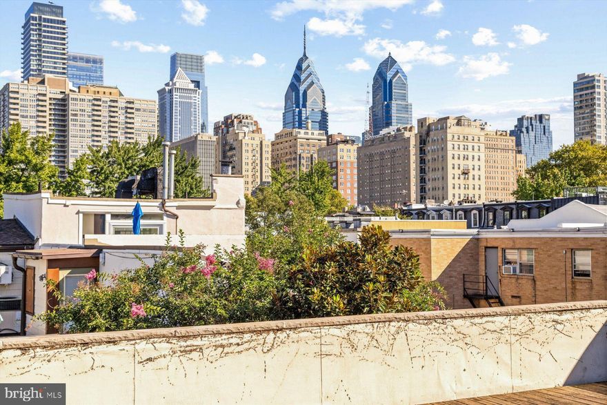 This architecturally significant home, designed by noted architect Adele Santos, was thoughtfully crafted to enjoy breathtaking 33' wide city views while maximizing light, space, and functionality across three levels. Located on a charming tiny street, behind a modest, industrial-styled façade, the home offers an array of surprising expansive, light-filled live and workspaces. The first level includes a one- to two-car garage, a light- filled flexible studio/family room, and a separate in-law suite with private courtyard entry. The second floor features a dramatic open-concept living/dining/cooking multi-height space with natural light from windows and skylights. The second level includes a private ensuite bedroom and another private area for additional living space or bedroom with an adjoining bath. The expansive stairs to the third level incorporate an indoor garden space with platforms for trees, plants and seating, bringing nature indoors.  The third floor includes a loft space overlooking the living area and a magnificent 16 x 32-foot terrace with spectacular views of the Philadelphia skyline. The property’s unique design allows sunlight to cascade through the home, solving the typical issue of dark row homes in Philadelphia.
Recent upgrades have been made to HVAC, replaced window wall/sliders leading to the deck, garage door, and roof. Located just a few minutes walk from Rittenhouse Square and Graduate Hospital, and only 15 minutes from Avenue of the Arts and the University of Pennsylvania, this home offers the perfect blend of modern living in a highly desirable, walkable location.