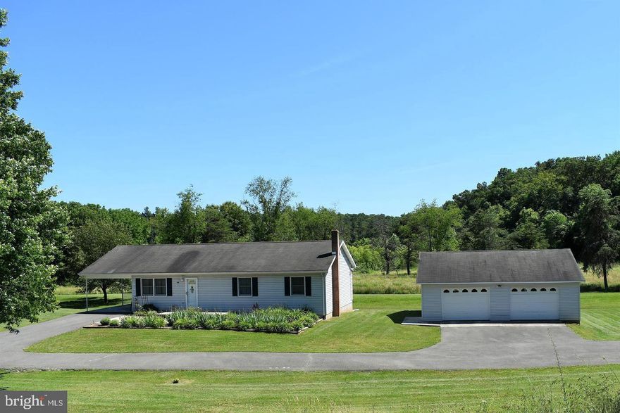 This ranch home offers the convenience of main floor living and features 3 bedrooms and 2 full bathrooms. The kitchen, complete with dining room, provides a comfortable space for family meals, while the living room and main floor laundry add to the home's functionality. The full unfinished basement includes a wood-burning furnace, providing additional heating options. The property includes a 1-car attached carport and an oversized 2-car detached garage, offering ample parking and storage. Situated on 3.71 acres, the home boasts a nice flat yard in a very quiet location with abundant wildlife. Recent updates include a new HVAC system installed in 2017, a new washer and hot water heater in 2019, a new stove and water softener in 2020, and a new refrigerator and microwave in 2022. The basement has also been equipped with new sump pumps, ensuring a dry and functional space. This home combines modern updates with the tranquility of a spacious, rural setting.