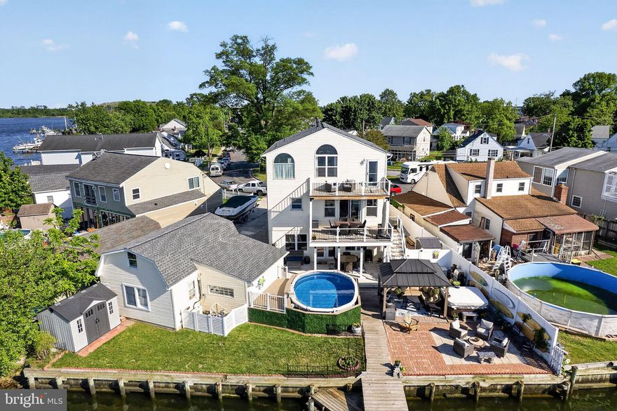 Welcome to 8224 Northview Road — a stunning 3-level waterfront retreat thoughtfully designed for luxury living, entertaining, and everyday comfort. Perfectly positioned along the water with breathtaking views, this exceptional property combines high-end upgrades, versatile living spaces, and incredible outdoor amenities.

The heart of the home is the expansive gourmet kitchen featuring stainless steel appliances, three ovens, a gas range with double oven, separate wall oven, microwave drawer, warming drawer, dual-basin farmhouse sink, Instahot system, trash compactor, wine cooler, and an oversized pantry complete with an additional refrigerator and freezer. The open-concept layout flows seamlessly into the main living and dining areas, creating the perfect space for gatherings while maximizing waterfront views.

Hardwood flooring spans the main and upper levels, while the finished walkout lower level offers durable luxury vinyl plank flooring throughout. The main floor also includes a private office and convenient half bath.

Upstairs, the spacious primary suite is a true waterfront sanctuary featuring vaulted ceilings, ceiling fan, oversized walk-in closet, and a private balcony/deck overlooking the water. The luxurious primary bath includes a dual vanity, jetted soaking tub, and separate shower. An additional full bath offers another dual vanity, jetted tub, and steam room for spa-like relaxation.

The fully finished walkout ground level is ideal for entertaining or multi-generational living with a complete second kitchen featuring a stove, oven, dishwasher, refrigerator, bar area, beer cooler, full bath, and laundry area.

Outdoor living is just as impressive with a covered porch, brand-new Trex decking, extensive paver hardscaping, gazebo, above-ground pool with Trex surround, and multiple waterfront entertaining areas. Boating enthusiasts will love the three boat lifts and premium waterfront setup.

Additional upgrades include a powerful 440-amp electrical service, detached garage with finished bonus room, and countless custom features throughout.

This rare waterfront opportunity offers the perfect blend of luxury, functionality, and resort-style living — all in an incredible location.
