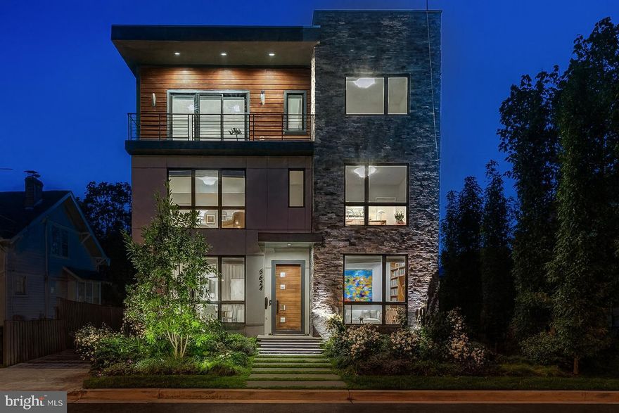 A Modern Masterpiece in the Heart of the Palisades. This exceptional 6-bedroom, 5.5-bathroom residence offers 5,150 square feet of meticulously designed living space across four levels. Built in 2019 by local builder Bo-Bud, the home boasts a striking blend of natural stone and wood paneling, creating a contemporary aesthetic that is both inviting and sophisticated. Floor-to-ceiling windows flood the interiors with natural light, enhancing the open-concept layout and highlighting the home's luxurious finishes.

Designed for modern living, the home features a gourmet kitchen equipped with top-of-the-line appliances, elegant primary bedroom with luxurious ensuite bathroom, a spacious third-floor loft with a wet bar, and multiple outdoor spaces, including a rear sun deck and two balconies. An elevator services all levels, ensuring convenience and accessibility. The landscaped backyard backs directly onto Carolina Park, offering unparalleled privacy and a serene natural backdrop. The front offers a modern layered garden, designed by Moody Graham, features perennial native plants and local bluestone walk and floating stairs.  Additional amenities include custom shades throughout, a solar array that all but eliminates electricity bills, UV coated windows on all rear windows and entire first floor, a two-car detached garage, driveway, and parking pad. All providing both functionality and style.

Situated in the highly sought-after Palisades neighborhood, this residence combines the tranquility of suburban living with the convenience of urban access. The Palisades is known for its tree-lined streets, strong community spirit, and proximity to the Potomac River. Residents enjoy a variety of local shops, restaurants, and recreational facilities, including the nearby Palisades Recreation Center and the annual July 4th parade, a cherished local tradition. With its blend of modern luxury and neighborhood charm, 5624 Sherier Place NW offers a unique opportunity to experience the best of both worlds.