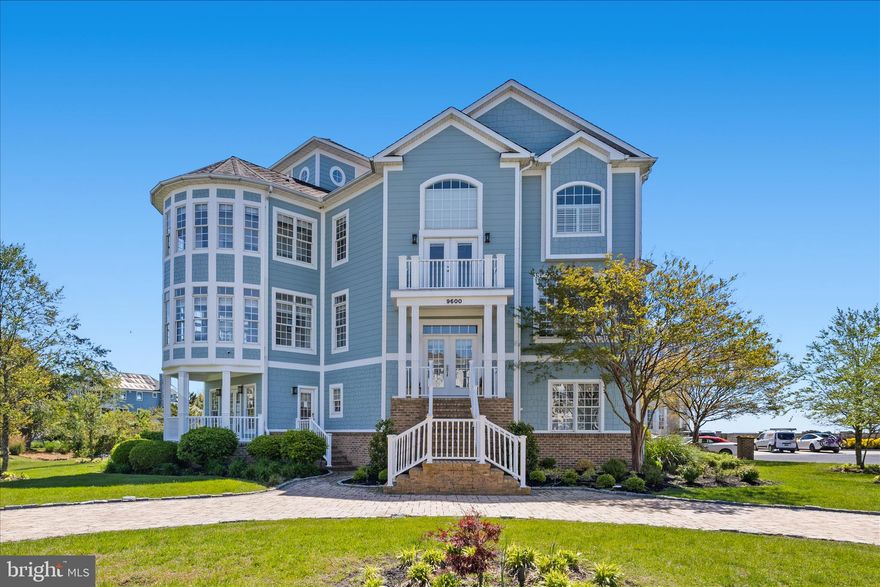 New pictures to be uploaded by May 15th!  Experience coastal luxury at its finest in this exceptional waterfront residence, offering sweeping views of the bay, Assateague Island, and the Ocean City skyline. Encompassing over 6,000 sq. ft., this elegant home is perfectly positioned on a quiet cul‑de‑sac surrounded by other distinguished coastal properties. A rare opportunity, it blends refined living with an unparalleled waterfront lifestyle and includes a deeded deep‑water slip accommodating a boat up to 35 ft.  Welcome to your coastal dream home.
First Floor - Enter through an impressive foyer that leads down to the first level—an inviting space ideal for guests or multi‑generational living. This floor features:  Two guest bedrooms and a full bath
A spacious living room with a fireplace and access to a bay‑view deck
The Captain’s Quarters: a private suite with its own exterior entrance, full kitchen, full bath, laundry, and interior access to the main home.  Main Level - A few steps up from the foyer, the main living area is designed for both grand entertaining and everyday comfort. Highlights include:  A formal dining room with wainscoting and abundant natural light.  A butler’s pantry leading into a gourmet kitchen with stainless steel appliances, granite countertops, custom cabinetry, pantry, and a large island with seating.  Dining area that opens to a spacious deck with direct water views.  Bright living room with a stone fireplace, wet bar, and expansive windows framing the bay, private den perfect for quiet moments or work‑from‑home needs.  Owner’s Retreat – Third Floor- The top floor is a luxurious sanctuary with breathtaking views. The primary suite includes: A generous bedroom with sitting area and fireplace, three walk‑in closets, spa‑inspired bath with double vanities, jetted tub, tiled shower, and water closet
An additional bedroom—currently used as a custom dressing room—can easily be converted back to a fifth bedroom. A convenient utility area provides space for morning coffee or snacks.
Follow the spiral staircase to the Coastal Overlook, a stunning vantage point offering panoramic views that must be seen to be believed.
Additional Features:  Elevator access to all three floors, hardwood and tile flooring throughout, thoughtful upgrades and refined finishes in every room.  HOA‑approved short‑term rentals, community marina, clubhouse, and pool with reasonable HOA fees.  This extraordinary home offers elegance, comfort, and unmatched coastal views. Schedule your visit today—your dream waterfront lifestyle awaits.