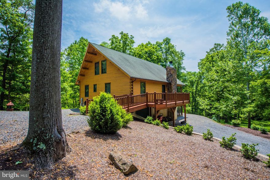 This very private well-maintained 3 BR, 2 BA, log home is on 3+ gorgeous acres just 3 miles from Berkeley Springs with 3 season view of Lake Siri at the newly renovated Coolfont Resort and Resturant.  The Kitchen has all maple cabinets with island. The living room has a wood-burning stone fireplace.  The living room, dining area, and kitchen are open and have hardwood floors.  Catwalk & sitting area overlooks the living area. Features screened and open porches screened patio and deck.  New furnace, heat pump, and water treatment systems. Large lower-level living space with laundry and finished garage. This property is move-in ready, all inspections completed and ready to close.