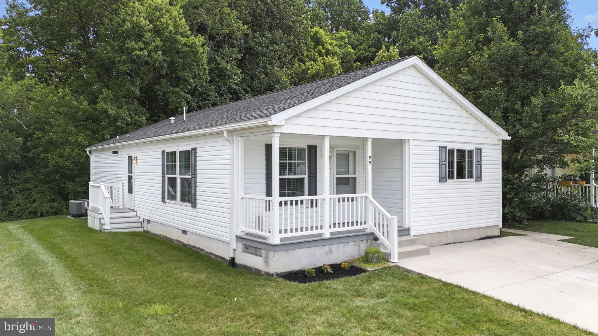 Welcome to 99 Curry Avenue located in Cinnamon Woods, a charming 55+ community ideally situated in Conowingo, MD. Discover comfortable, single floor living in this meticulously maintained manufactured home built in 2019. This residence offers a perfect blend of modern amenities and a relaxed lifestyle. The heart of the home is the eat-in kitchen, a true culinary delight featuring a stylish farmhouse sink, stainless steel appliances, a gas cooktop with a convenient pot filler, and a functional peninsula bar top. You'll appreciate the ample counter and cabinet space, perfect for all your storage needs. An open floor plan seamlessly connects the kitchen to a large living room, complete with a cozy electric fireplace – ideal for cool evenings or entertaining guests. This home boasts three spacious bedrooms and two full bathrooms. The primary bedroom is a private oasis, offering a bath en-suite with elegant lighted vanity mirrors, walk-in shower, and a generous walk-in closet. A dedicated laundry/mudroom adds to the home's practicality. Enjoy the outdoors from your inviting covered front porch entrance or relax on the side yard deck. An Amish-built storage shed provides extra space for your belongings, and two off-street parking spaces ensure convenience. Community living here is effortless with a range of included amenities. Residents benefit from access to a community building, lawn care, snow removal, and garbage removal, allowing you more time to enjoy your new home and surroundings. This is an exceptional opportunity for comfortable and convenient living in a vibrant 55+ community. Don't miss your chance to make this beautiful house your new home!