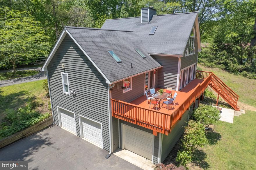 Presenting an exquisite unique, modern residence located in the highly sought-after Queen Anne Estates.  This stunning four-bedroom, two-bathroom home boasts a spacious three-car, side-loaded garage and is perfectly situated on a serene 2.13-acre lot.  As you enter the long private driveway, you're immediately embraced by a canopy of mature trees, offering both shade and seclusion.  The abundance of greenery and natural surroundings creates a sense of calm and privacy setting the tone for the tranquility that lies ahead.  Approaching the home, the three car garage is thoughtfully positioned for convenience and aesthetic appeal.  Continuing seamlessly to your left, the driveway curves to reveal an elegant circular drive that welcomes you to the front entrance of the home.  Upon entering the front of the home, you are immediately welcomed by an abundance of natural light and elegant hardwood flooring that flows seamlessly throughout the main living spaces, including the dining and kitchen areas  *  The kitchen offers stunning granite countertops, large granite island seating six, ample maple cabinetry, recessed lighting, skylight above in the kitchen and dining area  *  Off the dining area, a spacious living room boasts large atrium-style windows and french glass doors that bring the outdoors in, a cozy fireplace adds warmth and charm  *  Glass doors from both living and dinning room areas lead to an expansive deck that spans 3/4 length of the home  *  For ease and convenience, a laundry room and all four bedroom are located on the main level.  *  A full bathroom is situated off the main hallway, while the primary suite features a private en suite bath, offering a peaceful retreat  *  Ascending from the main hallway, you arrive at a spacious upper-level loft area, featuring cathedral ceilings, architectural windows and crafted banister that overlooks the expansive living room below  *  The lower level of the home offers an enormous multi-purpose room with  wall-to-wall glass windows and doors, seamlessly connecting indoors with the outside  *  Adjacent to this space is a generously sized bonus room thoughtfully soundproofed, ideal for home theater, studio or private workspace.  *  Access to and from the three car garage is conveniently located on this level, along with a large utility room equipped with a rough-in for a potential bathroom, abundance of storage space throughout making this level as functional as it is versatile.  *  Minutes from shopping at Bowie Town Center and the Annapolis Mall. Parks include Patuxent River Park and Annapolis High School's baseball field. For golf, there's the 18-hole Renditions Golf Course.