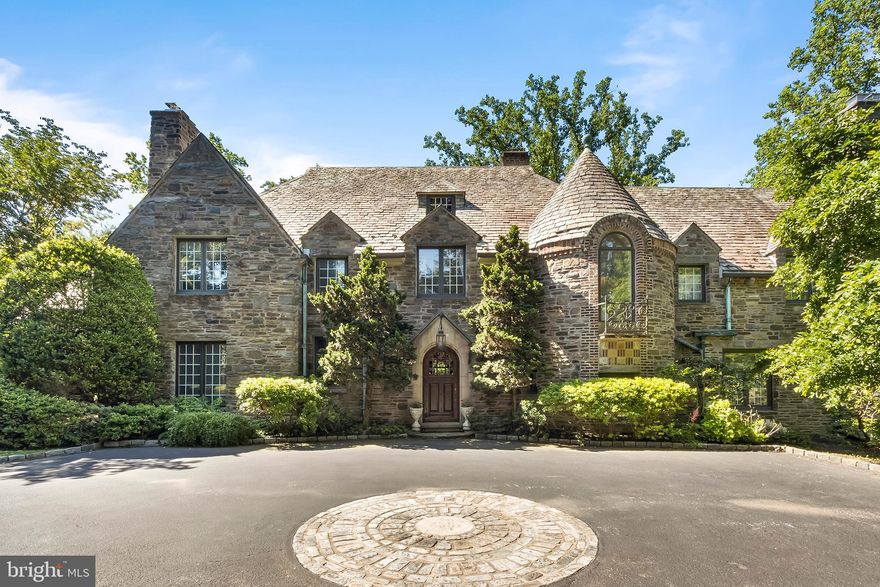 $600,000 PRICE REDUCTION. Now listed BELOW APPRAISED VALUE. You will definitely want to take a look at this unique property and take advantage of this rare opportunity. This stunning French Norman estate complete with a pool and tennis court displays the true elegance of a bygone era dating back to 1928. The unsurpassed craftsmanship and detail are evident from the moment one enters the courtyard. This spectacular home, situated in the heart of the Main Line, is on 2 plus acres and boasts a 4-car garage, multiple terraces, a koi pond, and everything needed for elaborate entertaining.
Upon entering you are welcomed by high ceilings, exquisite moldings, stone and woodwork rarely seen in today's marketplace. It has been elegantly designed to incorporate both large and small spaces for intimate entertaining as well as larger more formal occasions. 
As you enter the Great Hall with its exquisite wood paneling and built-in shelving you are welcomed with a fireside Sitting Area or Cardroom. This leads through arched doorways to an elegant Solarium overlooking multi-tiered terraces and the pool. There is a step-down Living Room enhanced by a stately stone fireplace, a high tray ceiling with a center rosette medallion, and large leaded glass windows with decorative transoms. 
The quiet Study also features a private wet bar and window seat. A large formal Dining Room with an elegant triple window overlooks the pool and terrace area as well.  The Great Room is luxurious yet comfortable with a working bar for entertaining also featuring built-in shelves and cabinetry. The Eat-In Kitchen and service pantry is well equipped to host larger parties as well as everyday meals. There is an additional washer and dryer for excess linens and access to the attached 4 car garage. 
The second floor has a gracious main bedroom with tray ceiling His and Her private Baths and Dressing Rooms with custom cabinetry. There are 4 additional bedroom suites. with custom bult-ins. There is private access from the garage to an Au Pair or In-law Suite which includes 2 bedrooms with ensuite baths and a sitting area. Laundry facilities and stairs to a walk-up attic with large cedar closet complete this floor. 
A semi-circular stone stairwell takes you to the lower level where a large entertainment room with high ceilings and a massive fireplace leads to a covered porch, flagstone patio, and koi pond. You will find a gated wine cellar, changing rooms for the pool, and a large storage area on this level as well.

This home is timeless and elegant and centrally located. The exquisite rooms flow seamlessly, each offering unique details and exuding quality. An in-ground swimming pool, a tennis court, flat grassy lawn, mature landscaping, garage with parking courtyard, estate fencing are just a few additional features of this magnificent property This is a true gem in the heart of Philadelphia's Main Line suburbs Come visit, enhance, and make your own.