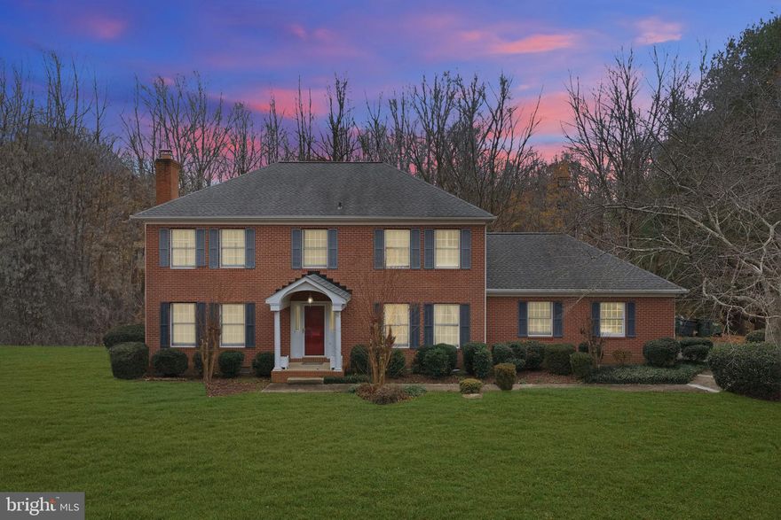 Welcome to this beautifully crafted all-brick colonial located in the sought-after Twin Lakes community of Huntingtown. Offering over 3,000 finished square feet of timeless design and modern comfort, this home impresses from the moment you step inside with hardwood floors, elegant trim work, and formal living and dining spaces centered around a cozy wood-burning fireplace.

The updated kitchen showcases new flooring and backsplash, Corian countertops, stainless steel appliances, and a sunny breakfast nook with peaceful views of the wooded backyard. Just off the kitchen, the family room opens to a refurbished deck—ideal for hosting, relaxing, or enjoying quiet evenings surrounded by nature. A main-level office behind double doors provides the perfect work-from-home space, while the oversized side-load garage offers abundant storage and workspace.

Upstairs, you’ll find four generously sized bedrooms with brand-new carpet, including an impressive owner’s suite with dual closets (one cedar) and a spa-inspired bath featuring heated tile floors, soaking tub, and an oversized multi-head shower. Major updates include a new roof in 2019 and both HVAC systems replaced, delivering peace of mind and long-term value.

With privacy, quality construction, and a prime location near top-rated schools, this home offers the space and setting today’s buyers are looking for.