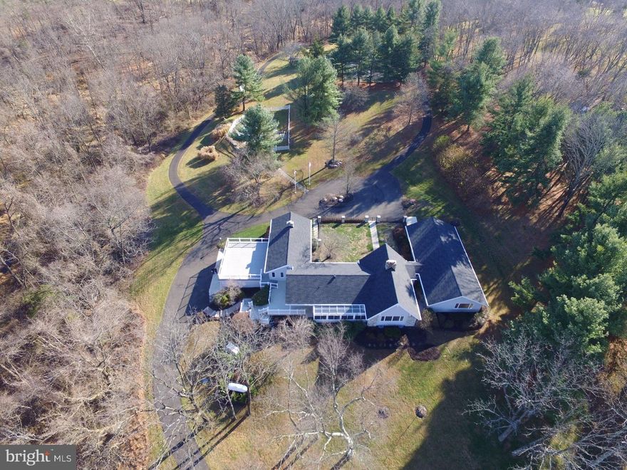 Welcome home to Hill House. Sited perfectly on 10+ acres on a storybook Upper Makefield hillside setting sits this beautiful house and spectacular property. Featuring the ultimate in privacy, with hundreds of mature well maintained trees, spectacular long distance views, changing topography and low lying creek, the property is located directly across the road from two of Upper Makefield's most prominent and historic properties, "Headquarters" and "Jericho Farm", which sit side by side and with each consisting of over 140 acres. With views from just about every room and every angle and bathed in continuous natural light, the property will be your sanctuary and private oasis all year round. Featuring a tumbled stone foyer entry, 4 bedrooms, 4 full ( including 1 in lower lever ) and two half baths, living room with floor to ceiling stone fireplace, dining room, family room with exposed beams and floor to ceiling fireplace, screened in porch, sunroom, kitchen/breakfast room with new stainless steel appliances including wine fridge, 42" cabinets, granite counter tops, laundry room; with all rooms very spacious and perfectly in scale and on one floor. There is also a circular staircase from the foyer to a loft/office, and a large partially finished basement with tons of storage and cedar closet on the lower level. The two garage door, double tandem garage bays will hold between 6-8 vehicles. A new, maintenance free 24' x 24' deck sits on top the garage and offers unparalleled views and large space for outdoor entertaining. There is a back up generator, 1/8 mile paved walking trail, in ground pool, tennis court and archery range to complete the unique features of this incredible property. Finally, in 2016, the sellers have installed a new roof, new oil tank, removed an in ground oil tank, and painted the interior and exterior 100%. This prime property is covered under ACT 319, which allows for lower property taxes. All in all, an incredible opportunity awaits the discerning buyer seeking a one of a kind property, just minutes from Newtown Boro in the heart of Upper Makefield.