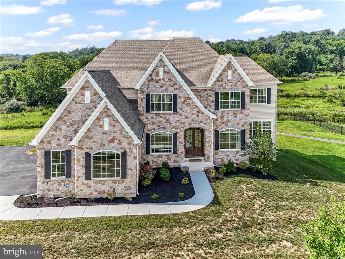 Welcome to 115 Parkview Way, a luxurious residence offering an expansive 5,791 square feet of living space in the beautiful Ventry at Edgmont Preserve. This stunning home built in 2023 boasts six spacious bedrooms and five and a half well-appointed bathrooms, providing ample space for family and guests.
As you enter, you are greeted by a grand foyer that sets the tone for the elegance found throughout the home. The main living areas feature hardwood flooring providing a rich texture and style to each room. Oversized windows invite natural light, enhancing the warmth of the working fireplace in the cozy yet expansive living room. The gourmet chef’s kitchen is a focal point, equipped with stainless steel appliances, including a double wall oven, gas stove and sub zero fridge. The open kitchen design, complete with a large island, wet bar with ample cabinetry, beverage fridge and walk in pantry, flows seamlessly into the eat-in kitchen area, perfect for entertaining. Overnight guests will enjoy privacy in the first floor bedroom and full bathroom that lends itself to easy access to the three car garage, mudroom area, back staircase, storage closet and a first floor powder room.
Retreat to the primary ensuite, featuring beautiful mosaic tile, a separate shower, soaking tub, and double sinks. Enjoy the convenience of two custom walk in closets, providing ample storage and a relaxing sanctuary. Additional features include a formal dining room, home office, library/den. Each second floor bedroom has its own private bathroom with two of the bedrooms on each side of a jack and jill bathroom with separate shower area. The property offers a full basement, ample parking, The Ventry at Edgmont Preserve clubhouse home to a refreshing pool, basketball court and party space or just relaxing. Central AC, forced air, and gas heat ensure comfort year-round, while the second floor laundry room with washer and dryer adds convenience to everyday living. This remarkable home is truly a must-see!