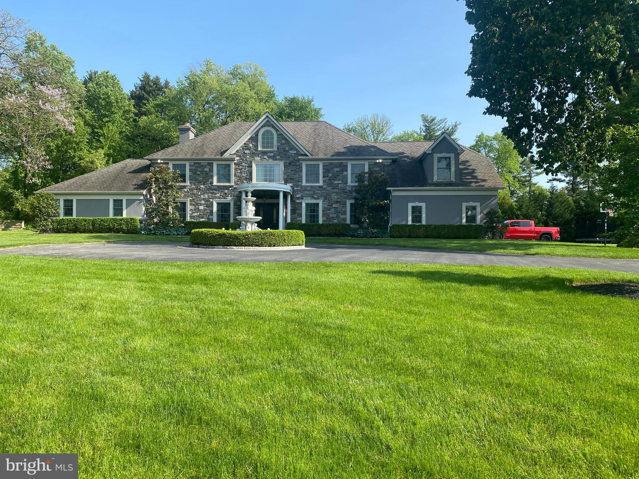 Tucked away in a secluded cul-de-sac, yet still located in a beautiful tree-lined neighborhood and sitting on a 1 acre flat lot, you will find 9 Tracy Ter, the Main Line home you have been waiting for. Driving in from the wide cul-de-sac, up the long tree-lined driveway provides you with two entry options. Veering to the right leads you to the over-sized 3 car attached garage structure with your everyday family entry into the mudroom from the garage. For your guests, veer to the left and they will be beautifully greeted by the circular driveway and two-story grand foyer, beautifully accented by a fountain in the middle of the driveway. Entering through the front door, you will find a stately, grand-formal dining room to the right and a spacious formal living room to the left which overlooks the front of the property. Straight ahead brings you to the gourmet eat-in kitchen which boasts a large two-tiered island, two sinks, dishwasher, 48” Viking range, and two Miele refrigerators/freezers. Located just off the kitchen is an entertainer’s dream. A Full wet bar, gathering area and stone fireplace that overlooks and flows beautifully into the large octagon-shaped great room in the back of the house. The great room features 12 foot ceilings, custom millwork and is perfectly situated on the property to access the impressive flagstone patio in the back yard. The first floor also boasts 1- half bathroom as well as a full bathroom inside the bonus room which could be used as either a first floor office/study, or a first floor master suite, or in-law suite. The 2nd floor features 4 large bedrooms and 3 full bathrooms. The primary suite bathroom includes multiple vanities, large walk-in shower, soaking tub and more. Just off the back of the primary suite is a walk-in closet and sitting room or exercise room. The finished basement is a great additional getaway space and also features an added un-finished bonus area that could be used a wine cellar, theater room, or full fitness room.