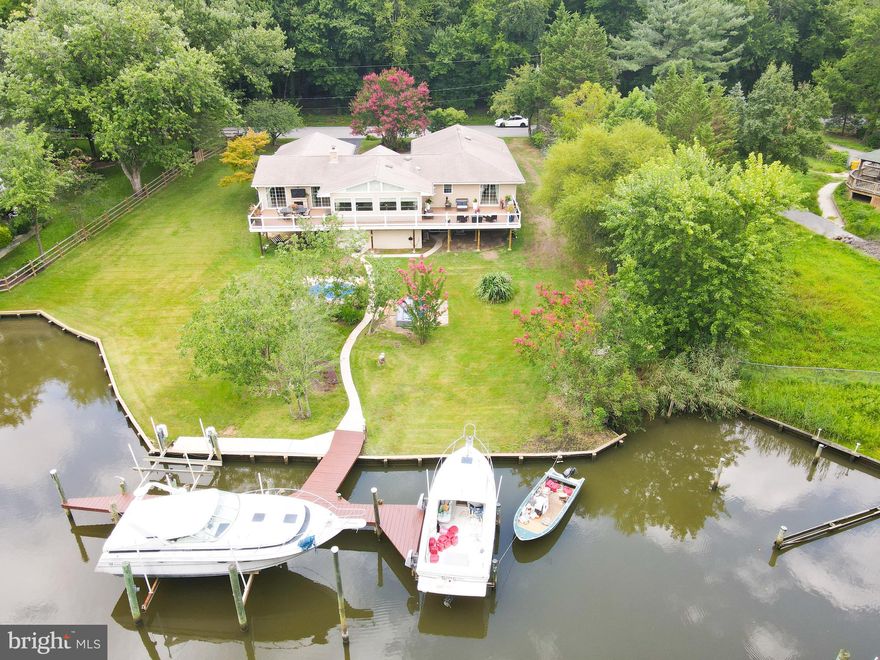 WOW!!! If you are looking for a waterfront home with an in-law suite, one level living, with a huge deck and 6 feet of mean low water, you should see at this property. Outside this home boasts a partial stone front a huge maintenance free deck, an oversized two car garage and a pier with enough room for 3 to 4 boats and 3 boat lifts . Inside features new Luxury Plank Flooring through the main part of the home, a stone fire place a giant kitchen with a breakfast bar, stainless appliances, 3 convection ovens, granite counters. Three spacious bedrooms including the Master Suite with water views access to the deck and an incredible bathroom. The Lower level has another bedroom , full bathroom, Family Room, and kitchenette, there is a sliding glass door to the back yard. Don't miss this home if you are in the market for a great waterfront property.
