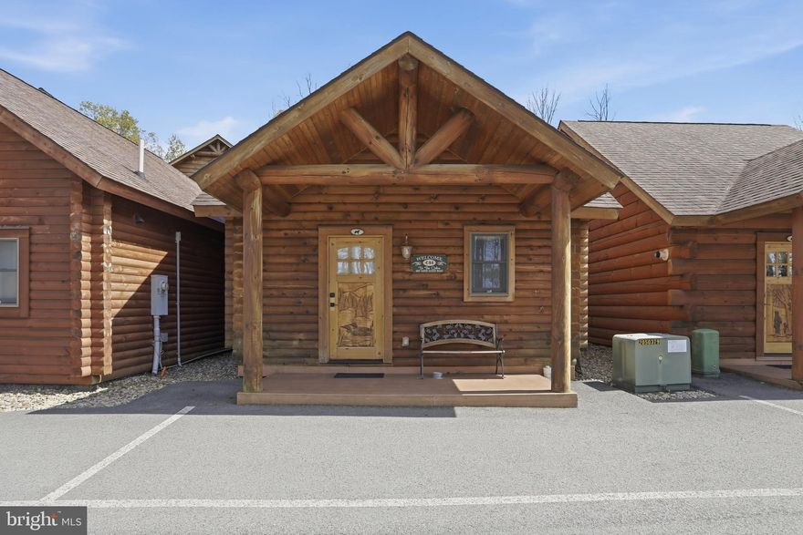 Cabin #44 at The Lodges of Sunset Village is a detached efficiency unit with a living room area with a sleeper sofa, king bed, a full bath, a kitchenette, and approximately 576 square feet, fully furnished and turnkey. This unit has a porch and patio too!

Rich in mountain character and charm, this log cabin features uniquely carved wooden doors, beautiful beamed ceilings, warm wood walls, and inviting spaces that create an authentic lake-and-mountain retreat feel. Additional features include lake and ski slope views, expansive decks, upgraded finishes, open-concept living, a stacked-stone gas fireplace. Enjoy incredible views of Deep Creek Lake and Wisp, along with front row seats for seasonal beauty and memorable moments, including views of the annual July 4th fireworks. 

This property has a proven rental history, generating an average of  $38,590  in annual gross
rental income creating an exciting opportunity for
buyers seeking both personal enjoyment and investment potential. Experience one of Deep Creek Lake’s
newest ownership opportunities at The Lodges at Sunset Village. For the first time ever, fully furnished lake
area cabins are being offered for individual ownership in a breathtaking community featuring incredible lake
and Wisp ski slope views. Community amenities include lake access with 10 shared dock slips and an
impressive 1,320 square foot waterfront dock area perfect for fishing, swimming, launching kayaks,
relaxing by the water, and enjoying summer fun at the lake. Residents and guests also enjoy a lakeside
gazebo, playground, fire pit, gathering areas, pet-friendly accommodations, abundant parking, and on-site
professional management. The monthly condo fee provides exceptional convenience, including most
utilities, snow removal, trash service, and yard maintenance, for a low-maintenance ownership experience. Whether you're searching for a vacation retreat, income-producing investment, or both, The Lodges at
Sunset Village offers a rare opportunity to own at Deep Creek Lake. Owner financing options may be
available. Stop by and see us at the Lodges Main Office or call today for details and your private showing!