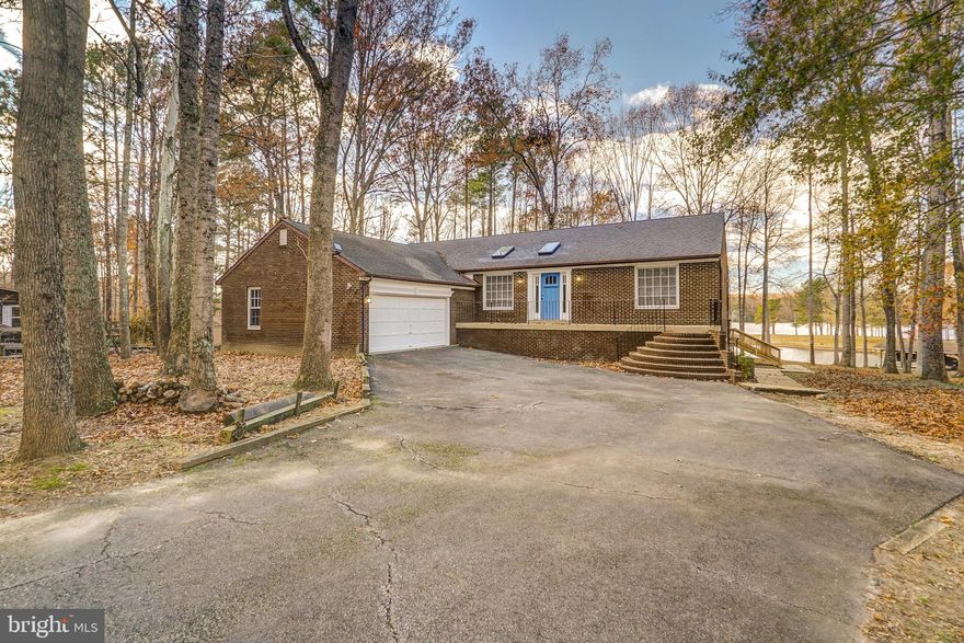 Escape and relax at this beautiful waterfront retreat located on the private side of Lake Anna. Private setting  with breathtaking views and 240 ft (+/-) of shoreline with two piers that have sun decks and each have a floating dock! This 3 BDRM, 3 BTH lake house is the perfect place for your family to gather and create memories to last a lifetime. Open floor plan makes it perfect for entertaining. Family room is open to the kitchen and dining area, that has sliding doors to the large deck that reaches across the entire back of the house. Stainless appliances and lots of natural light! Main level primary suite features two closets, a double vanity and a jetted tub. Two other spacious main level bedrooms. The fully finished walkout basement has lakeside sliding doors and offers a huge family room, rec room, wet bar, full bath and laundry room. Beautiful outdoor brick stove for grilling, BBQ's and entertaining! Two car garage and a paved driveway. Furniture and paddle boat convey! 
**12x16 deck was just redone 5 months ago, new skylights and flashing 2019, roof replaced 10 years ago, HVAC replaced 6 years ago, new stainless appliances 2021, new tile floors in primary bathroom 2021**