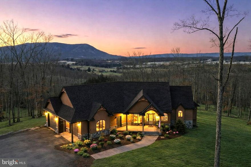 Panoramic mountain views that stretch for miles set the stage for this extraordinary custom-built estate, PRICED UNDER RECENT APPRAISED VALUE. Designed to capture breathtaking scenery from nearly every window, the home seamlessly blends refined luxury with the natural beauty of the Shenandoah Valley. Surrounded by the iconic Blue Ridge and Appalachian Mountains, this property offers a rare combination of elevated design, privacy, and awe-inspiring vistas—where every sunrise and sunset feels like a private showing.
This exceptional offering consists of two separately recorded 10-acre parcels, totaling 20 private acres. One parcel  features the primary residence and detached guest house, lake frontage and more. The second 10-acre parcel offers additional building potential, with a 4 bedroom perk and the ability to construct another primary dwelling and up to two additional dwellings. This configuration provides immediate flexibility for a private family compound, multi-generational living, future expansion, Airbnb potential or long-term investment strategy. Beyond the residences themselves, the land is equally compelling. Zoning permits livestock, offering the opportunity for a thoughtfully curated rural lifestyle—whether for land stewardship, hobby use, or the preservation of open space—while maintaining the refinement and sophistication of a premier estate.
The main house was thoughtfully positioned to maximize its sweeping views. Expansive windows frame rolling ridgelines and vibrant treetops. A stacked stone double-sided fireplace offers warmth and ambiance.
The gourmet kitchen features high-end appliances and premium finishes featuring a remarkable window overlooking panoramic mountain views, making even the simplest daily tasks feel relaxing. The owner’s suite serves as a private sanctuary with direct access to the covered porch and a spa-inspired bath complete with heated floors.
The finished basement offers impressive nine-foot ceilings and a beautifully crafted staircase that enhances the home’s architectural presence.
Outdoor living rivals that of a private resort.  An 8x12 ft multi-slide door opens fully to a massive covered outdoor living area featuring Trex decking, a stone wood-burning fireplace that creates a stunning vantage point for enjoying every season. The pool provides refreshing relaxation with mountain views and a private hot tub create a true resort-style setting. 
Function meets preparedness with an attached oversized 2-car garage, generator hookup, and a fully equipped RV hookup with electrical and clean out connections. A storage shed with electricity adds further versatility.
The guest house offers a beautifully appointed one-bedroom, one-bath layout complete with a gourmet kitchen, clawfoot soaking tub, walk-in shower, custom closet and jacuzzi hookup — ideal for guests, extended family, private retreat use, or potential income opportunity.
With abundant wildlife including deer and waterfowl, this property offers exceptional recreational opportunities such as fishing, kayaking, and a designated outdoor target shooting area. Combined with the added advantage of a separately recorded, buildable parcel, this offering presents a rare opportunity to own not just a home, but a true legacy estate and compound within the sought-after Estates at Lake John. The prestigious Lake John Estates community features private lake access and exclusive access to the North Fork of the Shenandoah River, blending privacy, outdoor recreation, fishing, wildlife watching, and the kind of timeless experiences that create lasting memories.
This is luxury, land, waterfront, and long-term flexibility — all in one extraordinary offering.