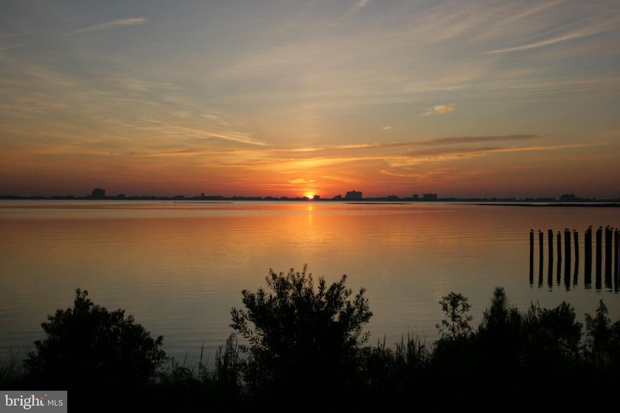 Savor the panoramic views of the Ocean City skyline and the bay from this luxurious 3 bedroom, 2 bath waterfront condo. The front door opens to an impressive 6x24 entryway, flowing into the gourmet kitchen, including a breakfast bar, walk-in pantry and under cabinet lighting. Numerous upgrades include geothermal heating and air, granite kitchen countertops, hardwood floors, Italian marble baths, 9 foot ceilings, crown molding, and a beautiful built-in barbecue grill with brick archway  on the private balcony. Get away from it all in your spacious primary suite with double walk in closets, balcony access and whirlpool garden tub. You will find exceptional quality in this building, containing a center stair tower lobby entrance with Crystal chandelier and bronze elevator. There’s a separate storage area, plenty  of guest parking,  and space for taking casual strolls around  the luscious landscaping with bridges, reflecting pools and fountains.  Seller to pay 2026 special assessment in full, to cover repairs to the Stair Towers, Lobby Front Doors, and Condo front doors, to protect long-term structural integrity.  Condo fees include energy-efficient geothermal heating and cooling maintenance, flood hazard insurance, shared system infrastructure maintenance, and major building upkeep.  When you break down what's covered, the condo dues actually replace many costs owners would otherwise pay individually.  All of this is located in the amenity-filled Ocean Pines community, conveniently located within a short drive to the beaches of Ocean City and Assateague Island National Seashore!