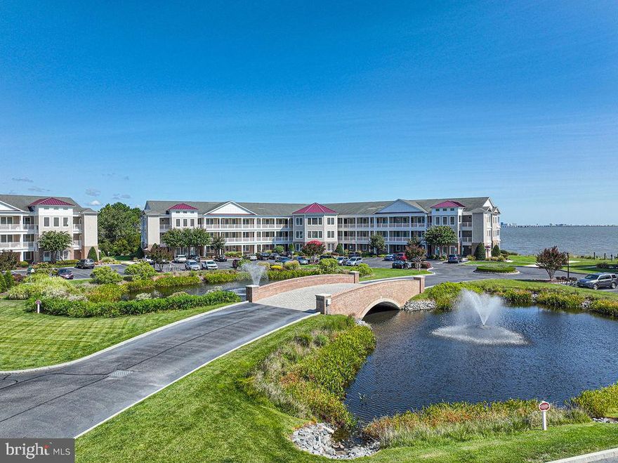 Savor the panoramic views of the Ocean City skyline and the bay from this luxurious 3 bedroom, 2 bath waterfront condo. The front door opens to an impressive 6x24 entryway, flowing into the gourmet kitchen, including a breakfast bar, walk-in pantry and under cabinet lighting. Numerous upgrades include geothermal heating and air, granite kitchen countertops, hardwood floors, Italian marble baths, 9 foot ceilings, crown molding, and a beautiful built-in barbecue grill with brick archway  on the private balcony. Get away from it all in your spacious primary suite with double walk in closets, balcony access and whirlpool garden tub. You will find exceptional quality in this building, containing a center stair tower lobby entrance with Crystal chandelier and bronze elevator. There’s a separate storage area, plenty  of guest parking,  and space for taking casual strolls around  the luscious landscaping with bridges, reflecting pools and fountains.  All of this is located in the amenity-filled Ocean Pines community, conveniently located within a short drive to the beaches of Ocean City and Assateague Island National Seashore!