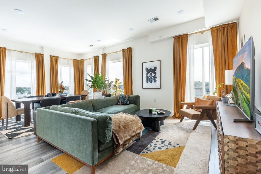 Welcome to 1148 N. 2nd Street #6F, a stunning corner bi-level penthouse and the largest floor plan in Northern Liberties' highly sought-after North Liberty Triangle. Perched on the top floor, this sun-soaked residence offers designer finishes, dramatic views, and seamless indoor-outdoor living—all in one of the city’s most vibrant neighborhoods.

The main level features an expansive open-concept living and dining area with floor-to-ceiling windows and exceptional natural light. The sleek modern kitchen is outfitted with quartz countertops, soft-close cabinetry, under-cabinet lighting, a large eat-in peninsula, and stainless steel appliances. Just off the kitchen, enjoy your morning coffee or evening wine on the private balcony overlooking 2nd Street. A full bathroom on this level adds convenience for guests.

The primary suite offers a tranquil retreat with floor-to-ceiling windows, a spacious walk-in closet, and a spa-like en-suite bath featuring dual vanities, contemporary fixtures, and a glass-enclosed shower with oversized tile. The secondary bedroom is generously sized with excellent closet space and easy access to the second full bath—perfect for guests, or a home office.

Upstairs, escape to your private rooftop oasis—an expansive composite deck with unobstructed 360-degree views of the Philadelphia skyline. Whether entertaining under the stars or soaking in a quiet sunset, this outdoor sanctuary sets the tone for city living at its finest.

Additional features include a full-sized LG ThinQ washer and dryer neatly tucked into a laundry closet, custom closet systems throughout, and a licensed GARAGE parking space with direct access to the building. North Liberty Triangle, completed in 2022, offers a secure lobby, fitness center, elevator, package room, trash chute, and beautifully landscaped courtyard. With low condo fees of $352/month and eight years remaining on the tax abatement, this home delivers exceptional value and lifestyle.

This is a rare opportunity to own a turnkey penthouse in one of Philadelphia’s most dynamic and walkable neighborhoods—steps from the best of Northern Liberties, yet quietly elevated above it all.