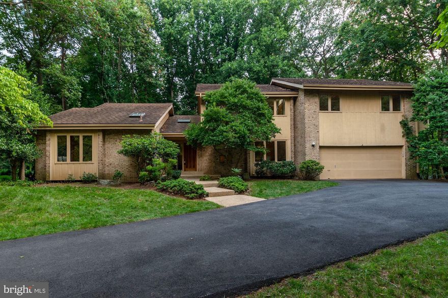 Welcome to 9145 Vendome Drive in the sought after Palisades neighborhood of Bethesda, Maryland.  This contemporary home framed in wood and brick on a tranquil wooded lot offers four bedrooms, three full bathroom and two half bathrooms. Enter the two story foyer with tile floors, skylight and natural light galore.  The main level is perfect in layout with all of the rooms you will need and hardwood flooring throughout.  A dramatic front home office with bench window seating and vaulted ceilings is just the room you have been needing this year. The nearby living room shows off a wall length floating wood cabinet and vaulted ceilings with fantastic walls for art and furnishings. The family room, also wrapped in windows and glass sliding door access to the rear deck stuns with floor to ceiling stone surrounding the gas fireplace.  The family room connects to the kitchen with a glamorous and open wet bar with glass shelves, mirrored walls and ready to entertain.  The kitchen has modern wood slat cabinetry, granite counter tops and an eat-in space for table and chairs.  A gourmet stainless steel appliance set awaits including a double oven, five-burner gas cooktop with designer stainless steel exhaust hood, wine refrigerator and warming drawer. A desk area with cabinets offer additional helpful kitchen space. The nearby dining room, visible from the foyer and easily accessed from the kitchen has a lovely chandelier, recessed lighting and windows overlooking the front landscaping.  A large mudroom with windows is conveniently located in-between the two car garage and the kitchen offering a sink, full size washer/dryer, powder room and rear door to the backyard. The open wood staircase takes you to the upper level landing with hallway to four bedrooms and three full bathrooms.  The primary bedroom has a double door entry to the oversized space with windows overlooking the rear yard and nicely flows into a sitting area convenient to each of the two generous walk-in closets. The large primary bathroom offers a double vanity,  jet bathtub, and separate shower. The upper level offers three additional bedrooms with two full bathrooms, one located en-suite. The lower level offers opportunity galore and offers over two thousand square feet of potential! Outdoor space awaits with a large deck stepping down to an open grassy area framed with mature trees along the perimeter for the ultimate privacy. The desirable Palisades neighborhood is surrounded by serene Rock Run parkland and a creek with easy access just steps from the house.  Convenient to the C&O canal, trails and the Potomac River, this location is both a commuter and nature lover’s dream!
