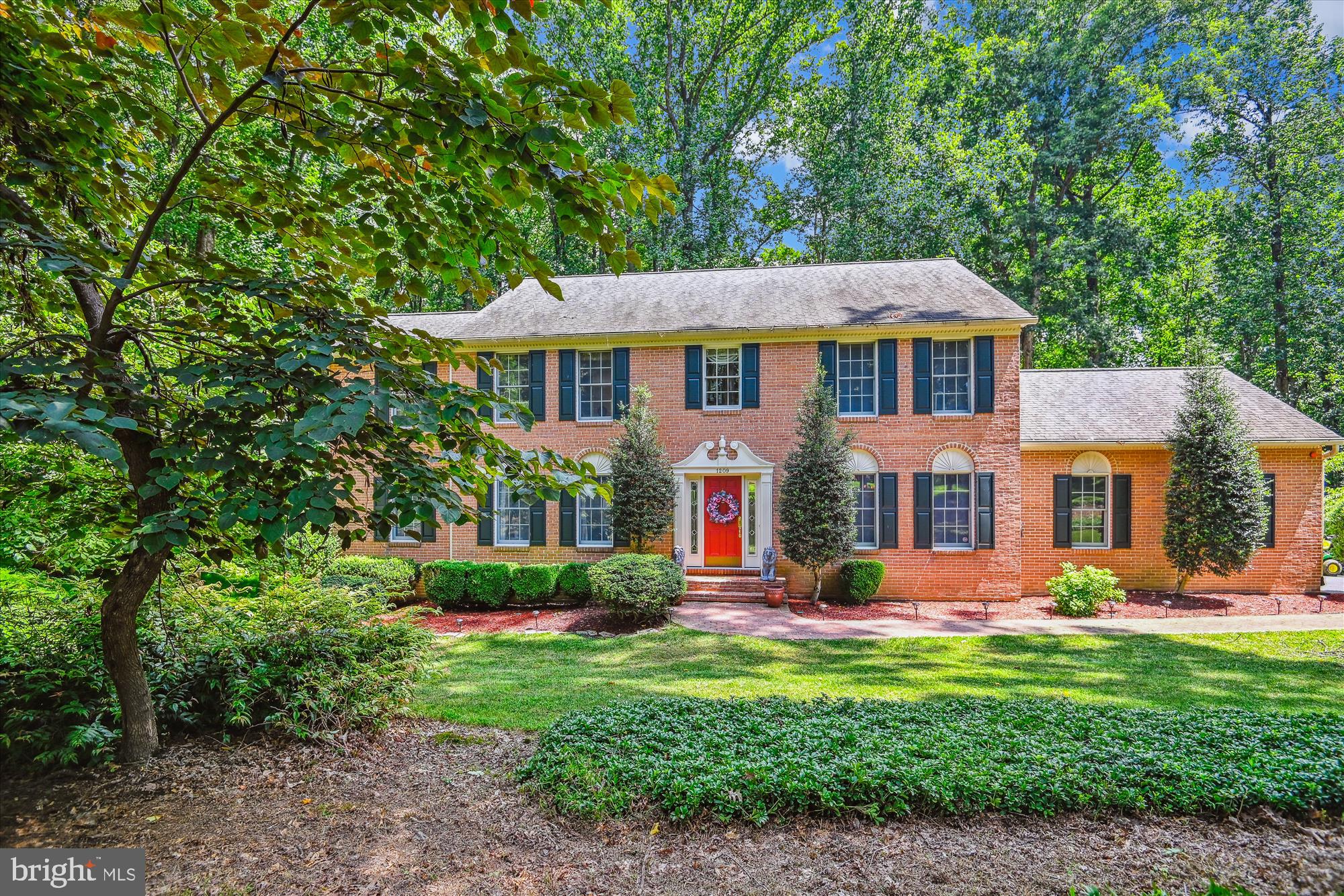Nestled on a serene 3.19-acre cul-de-sac lot in the Meadowood community, surrounded by trees and gardens, this stunning custom brick-front colonial offers over 4,100 sq ft of refined living space and elegant architectural details.
Step inside to a grand foyer with hardwood floors that flow into formal and casual living areas. The living room opens through French doors to a private study adorned with beautiful built-ins. A dramatic family room features two-story lunette windows flanking a gas fireplace and access to a spacious Trex deck overlooking wooded views.
The formal dining room is enhanced by heightened windows, a classic chandelier, and a convenient butler’s pantry. The kitchen boasts quartz countertops, cabinets, appliances, a sink, a center island, and a sunny breakfast room with a cathedral ceiling and floor-to-ceiling windows.
Upstairs, the impressive owner’s suite includes custom built-ins, a sitting room, two walk-in closets, and a spa-like bath with a soaking tub and separate shower.
The expansive finished lower level offers excellent in-law suite potential with a full kitchen, recreation room with gas fireplace, game room, bedroom, full bath, extra storage, and a level walkout to the peaceful backyard setting.