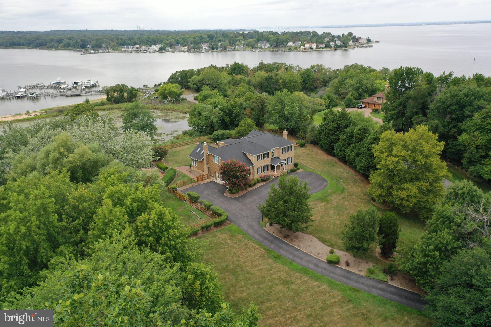 Welcome to 8100 Pinehurst Harbour Way, a waterfront, fully renovated, beautifully landscaped, four-bedroom, five bath, attractive home. With spectacular sunsets and fabulous water views of the Bodkin Pointe Marina and Bodkin Creek, an estuary of the Chesapeake Bay, and overlooking gorgeous wetlands with spectacular wildlife, this inviting traditional home sits up high on 3.3 acres in upscale private Bodkin Pointe, a gated gem near Gibson Island and Downs Park boasting its own marina, tennis courts, and common areas. Settle back on the exterior main level back deck, or on the wrap around deck upstairs off the master bedroom, both of which overlook these magnificent views, or bask pool side, take a refreshing dip in the swimming pool, or walk to your private sandy beach by the marina, and then hop on your boat on your private slip in the marina! Make sure to watch the video!
With glorious water views from many rooms, enjoy cooking in the gourmet kitchen, relaxing in the adjoining family room, working at home in the office, reading in the den, and entertaining in the dining room while others unwind in the enormous finished lower level with wet bar.
Built in 1990 and renovated over time between 2014 and 2018, this house is built for gracious entertaining and comfortable living.