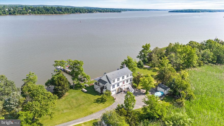 Remarkably exclusive waterfront home in Chesapeake City! 151 2nd Street is situated on 11 acres with 1600 feet of shoreline along the Elk River and features a private dock with a boat lift and jet ski lift, plus a boat ramp. At low tide, the property reveals a gorgeous, massive sandy beach just around the point. Inside, the open, expansive main level features oak hardwood flooring and neutral colors that carry throughout most of the home. The large living area with wood-burning fireplace has plenty of room to gather with family and friends. The sunroom features breathtaking panoramic water views – a great spot to sit and watch the ships as they travel through the intracoastal waterway! You’ll love the updated kitchen, complete with tile flooring, granite counters, tile backsplash, under-cabinet lighting and stainless-steel appliances. The generously-sized primary bedroom is conveniently located on the main level also. The stunning primary bathroom has heated flooring, an updated vanity, and a large shower with tile surround and glass door. Additional living space in the front of the home can serve as a formal dining room, office, recreation or craft room! The laundry room and powder room round out the main level. Upstairs you will find two large bedrooms with oak hardwood flooring, great storage, and a full bathroom. The downstairs level serves as the two car garage and additional unfinished space. Outside, two storage sheds can serve to house your watersports and gardening needs. Whether you’re on the waterview deck, in the back yard, or at the end of the dock, there are endless spots for morning coffee and evening relaxation. Take your pick! The tidal wetlands, which constitute the majority of the property, are excellent for waterfowl and deer hunting and provide an incredible barrier for added privacy! The uniqueness of this property truly cannot be overstated – it is one of a kind! Shaded property boundary in listing photo is approximate.