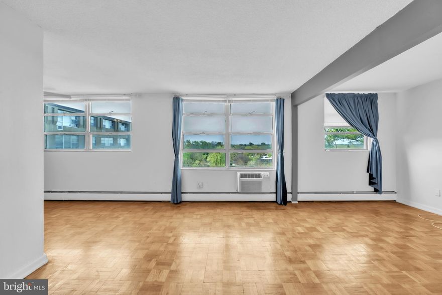 This spacious ONE-BEDROOM residence with an ADDITIONAL DEN/OFFICE is located on the 9th floor of RADNOR HOUSE, offering a highly desirable layout and peaceful treetop views OVERLOOKING THE COMMUNITY’S PARK-LIKE GROUNDS. The popular floorplan features a generously sized living room with a distinct, SEPARATE DINING AREA—ideal for both everyday living and entertaining. Beautiful HARDWOOD FLOORS run throughout the space, adding warmth and elegance. 
The kitchen is well-appointed with ample cabinet storage, a gas stove, refrigerator, and DISHWASHER, making it both functional and convenient. Just off the living room, the versatile den includes a closet and can easily serve as a home office, guest space, or reading room. 
Residents enjoy a full suite of amenities such as a 24-HOUR FRONT DESK, on-site storage, and access to a beautifully maintained OUTDOOR POOL AND PATIO AREA. The expansive grounds feature lounge chairs, umbrellas, grilling stations, and even a playground, all set against lush landscaping. A large OUTDOOR PARKING LOT is available at no cost and connects directly to a nearby township park, while INDOOR GARAGE PARKING may be available through management for an additional monthly fee. 
The building also offers a modernized lower-level LAUNDRY FACILITY for added convenience. This prime Main Line location places you within WALKING DISTANCE to the train station, as well as the vibrant shops and restaurants of Bryn Mawr. NEARBY INSTITUTIONS include Villanova University, Bryn Mawr College, and Harcum College. You’ll also find EASY ACCESS to the Bryn Mawr Film Institute, local hospitals, scenic hiking trails, and major roadways including I-476 and I-76, connecting you quickly to King of Prussia, Center City Philadelphia, and Philadelphia International Airport. 
Combining comfort, convenience, and a prime location, this unit offers an exceptional opportunity to enjoy Main Line living at its best.