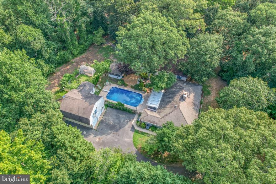 This home offers more to the eye. Spacious open home offers 2 large bedrooms, 2 full baths, separate dining room, kitchen with table space. Spacious Family Room with wood stove built into fireplace that leads to the Florida room overlooking the inground heated pool. 
Separate full bath for Pool area just outside of Laundry Room. Decking off pool leads to a screen in porched. Large, detached garage.  Separate fenced in gardens with Greenhouse. Additional Garage with office, rec room, etc. with separate private entrance and private driveway. Home rests on 1.95 acres with mature plantings overlooking farmland in the front and walk to the back of the property and enjoy a evening with a firepit next to Mason Branch.