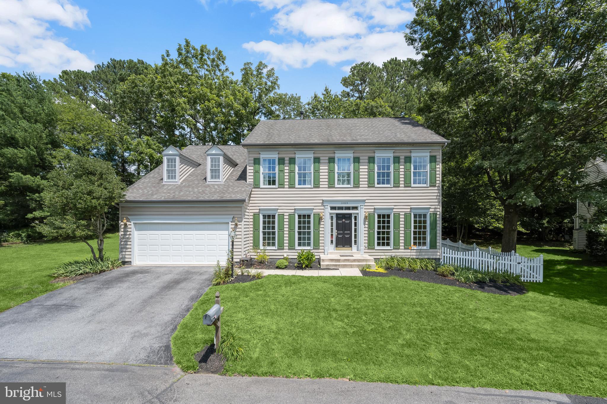 Upgraded Colonial with Flexible Living in Gaither Hunt
Welcome to 11025 Gaither Hunt Lane—a beautifully updated colonial nestled on a quiet corner lot in the highly desirable Gaither Hunt community in Columbia. Backing to mature trees and surrounded by lush landscaping, this home on a spacious corner lot offers a perfect blend of indoor and outdoor living space.
Step into a bright two-story foyer that opens to a versatile flex room, perfect for a home office or playroom. Just beyond, the main level offers a formal living room and dining room enhanced by elegant details such as crown molding, chair rail, and updated hardwood flooring.
The heart of the home is the fully renovated kitchen, featuring hardwood floors, a center island, breakfast bar, cooktop, double oven, stainless steel appliances, and ample cabinetry. The adjacent breakfast room includes a large center picture window that brings in natural light and offers a peaceful view of the backyard. The kitchen unfolds seamlessly into the family room, also upgraded with hardwood floors, a brick fireplace, and recessed lighting create a warm, inviting space. Meander outside from the family room or the breakfast room into the rear screened porch, then step out onto an expansive patio for dining alfresco or gathering under the stars. This idyllic setting is perfect for relaxing or entertaining. Two side yards and a charming picket fence with dual entry gates completes the outdoor experience.
Upstairs, the home offers a spacious primary suite with cathedral ceilings, private sitting room enclosed with French doors, and a renovated en-suite bath featuring a walk-in shower, freestanding soaking tub and modern finishes. Three additional bedrooms share a full hall bath, providing ample space for family or guests.
Additional features include a two-car front-entry garage with inside access, driveway parking for four vehicles, and a full walkout basement with a rough in for a full bath and easy access to the rear activities. rear access—offering exceptional potential for future expansion . Located within the top-rated Howard County Public School system and just minutes from Columbia’s best shopping, dining, and commuter routes, this home delivers the space, style, and setting that today’s buyers are looking for.