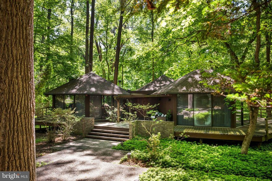 Tucked away on a private 2 plus acre wooded lot centrally located in the coveted Caves Valley, this one-of-a-kind architectural retreat is a celebration of creativity, nature, and timeless design. Composed of striking geometric hexagon pods, walls of glass, and fully wrapping decks, this distinctive deck tree house embraces its mid-century spirit while offering a living experience unlike any other. If you have ever dreamed of living in your own unique tree-house setting, with the utmost privacy, you have found the one. 

At the heart of the home, a dramatic great room and dining space soar beneath warm wood-paneled beam ceilings, anchored by a stunning wood-burning fireplace that draws the eye upward and invites gatherings both intimate and grand. Just beyond, a quintessential 1970s wet bar creates the perfect setting for entertaining and conversation.

The centrally located kitchen is thoughtfully designed for both form and function, featuring granite countertops, updated appliances, floor-to-ceiling cabinetry, impressive space saving built-ins, and direct access to the rear deck—ideal for grilling, dining beneath the trees, or enjoying a glass of wine with book in hand.

The home's additional two main bedrooms each feature ensuite bathrooms, wood vaulted ceilings, loft spaces, and oversized glass sliders connecting one with nature at every turn. A second great room doubles as a den, possible third bedroom, or home office, depending on ones needs, and inspires creativity and quiet reflection. It is complete with custom built-ins for the avid reader, a free-standing pellet stove, and an elevator that serves the lower utility level of the home. 

Designed for artists, visionaries, and those who seek a deeper connection to their surroundings, this remarkable residence frames ever-changing woodland vistas in every season—from the fiery hues of autumn to the lush greens of summer. 

Thoughtfully maintained and updated, the property includes many recent improvements including new flat and pod roofing (2024/2025), heating system (2023) and hot water heater (2024). 

Rarely does a home so beautifully blur the line between architecture and art. Beloved by the same family for several decades, the time has come for this special home's next steward to enjoy it not simply as a place to live, but a place to imagine, create, and thrive.