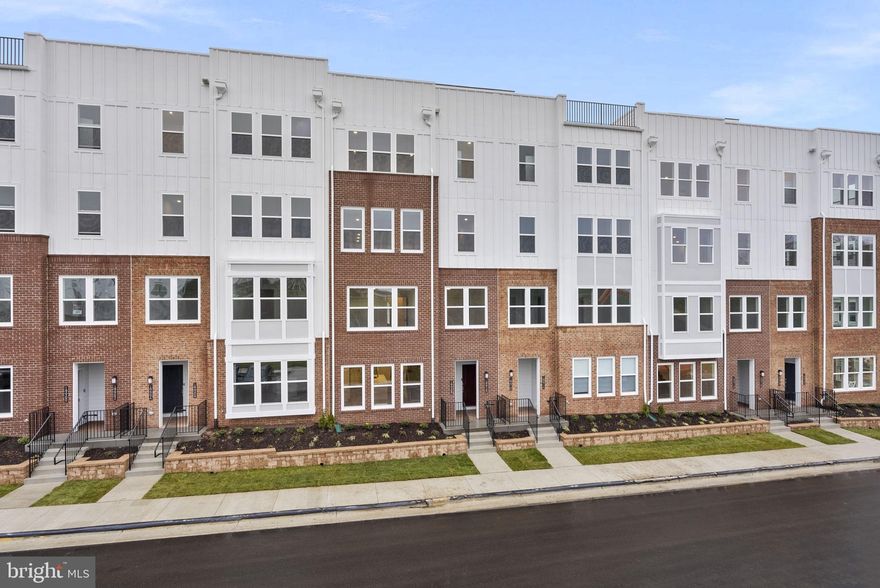 Welcome to this brand new three bedroom, two full one half bath condo on 1,520 square feet across two levels in the brand new community of Belmont Overlook. The main level can be accessed through the front door or rear-load finished one-car garage, which includes an electric car rough-in. This level features upgraded 7" wide luxury vinyl plank flooring spread across an open-concept floor plan featuring a family room with added recessed lighting, breakfast area, gourmet kitchen, walk-in pantry, coat closet, and powder room. The gourmet kitchen features quartz countertops, cascading kitchen island, upgraded stainless steel appliances, pure white ceramic backsplash, under-cabinet lighting, modern pendant lights, and range hood.  As you walk upstairs, you'll notice oak stairs with upgraded wrought iron balusters.  The second level features carpet in the bedrooms, but upgraded luxury vinyl plank flooring in the hallway. Directly off of the stairs is the primary bedroom featuring two extremely large walk-in closets, a private balcony, added recessed lighting, and primary bathroom featuring a frameless glass shower door, quartz-topped dual-vanity sinks, and your own linen closet. The laundry room is conveniently located right off of the primary suite. A large hall bath is adjacent to the two large secondary bedrooms featuring quartz-topped dual-vanity sinks. This home is situated just steps away from a vibrant shopping center featuring Whole Foods, a variety of restaurants, coffee shops, and more. With easy access to Route 7, just minutes from One Loudoun, one exit away from Inova Lansdowne, and 20 minutes to Dulles Airport, you’ll have everything you need right at your fingertips.