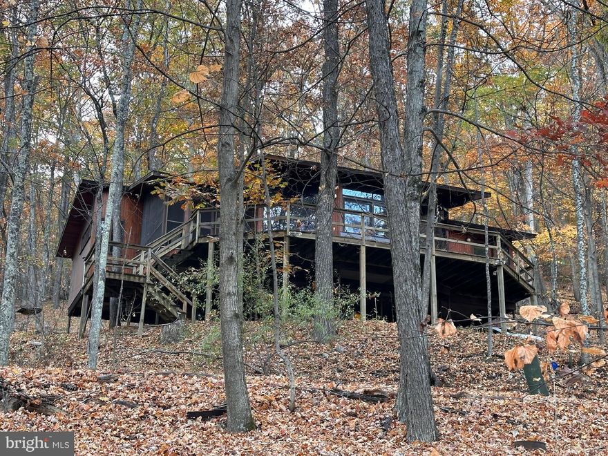Beautiful 3 bedroom, 2 bath home in Coolfont Mountainside.  Custom windows for a near panoramic view.  Expansive deck and screened in porch.  Wood burning fireplace, hardwood floors, and many beautiful wood accents.  Master bedroom suite and beautiful stone work.  A basement workshop and storage area underneath and room to park underneath as well.  Close to downtown Berkeley Springs and close to Cacapon State Resort Park.  Community offers a pool, hot tub, hiking trails, tennis courts, playground, and much more.