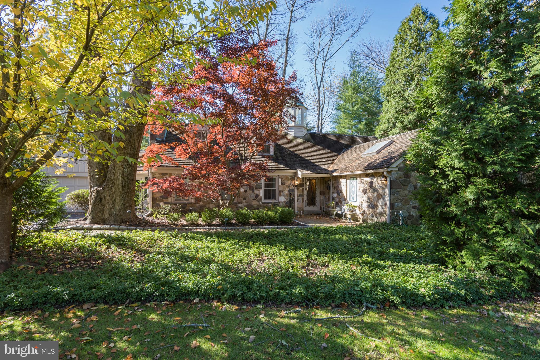 This fabulous four bedroom, 4.1 bath cape style home is located in one of the Main Line's most sought-after neighborhoods. The home is surrounded by more than 3/4 of an acre of gorgeous park-like grounds which makes sitting at the private swimming pool feel like you are on vacation. The pool house is convenient for housing all of the pool supplies and equipment and can serve as a changing area as well. Enter this beautiful stone home through the center hall and you will find bright eat in kitchen equipped with Thermador and Bosch appliances and a large Sub Zero refrigerator. The center island adds to the plentiful counter space and there are doors leading out to a maintenance free composite deck for barbecuing and dining. The dining room is conveniently located off of the kitchen and can accommodate large gatherings. The spacious living room located off of the dining room allows for a seamless floorplan for entertaining. The main level is completed by a large and cozy family room with beautiful wood built ins, a bar area, an additional room connected with large glass greenhouse like windows which can be used as a sunroom, gym, office, playroom, etc. The possibilities are endless. The first floor features the convenience of a master bedroom. The bedroom features a tremendous amount of living space and an entire wall is outfitted for all of your clothing and shoes. The master bathroom is quite spacious with ample counter space and storage and a large shower. Beautiful hardwood floors in the dining room and living room as well as throughout the hallway complete the first floor. The second floor has three large bedrooms and two full bathrooms. One of the bedrooms is so large it could be used as a playroom, joint office, gym etc. There is a wide open hallway that connects the bedrooms and bathrooms in addition to more closet space. The lower level completes the interior and has two separate areas that can be used for a playroom, office, gym etc. and an additional full bathroom There is also a laundry room with plenty of space for hanging clothing and staying organized . You won’t want to miss this treasure on one of the prettiest streets in the Main Line!