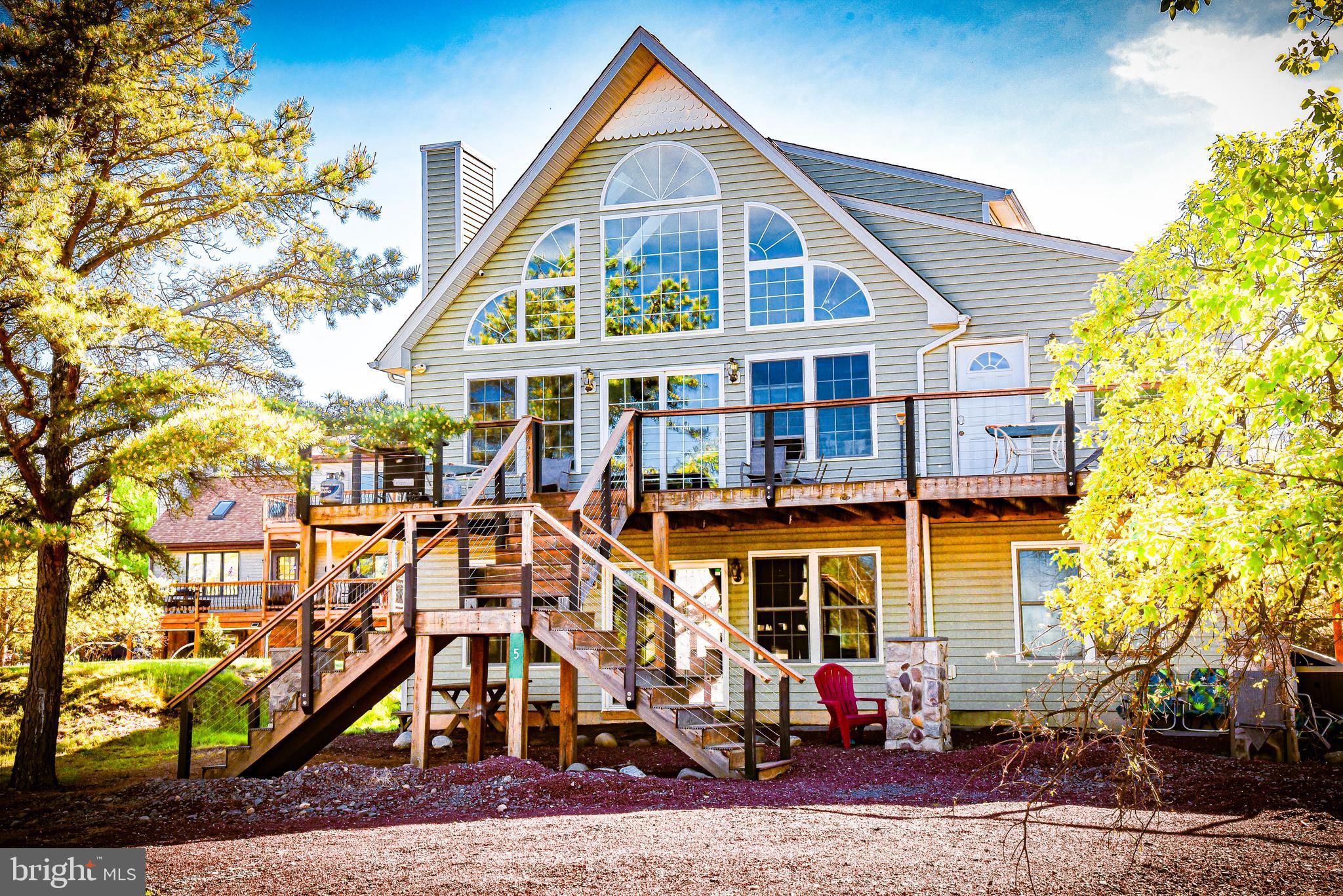 This gorgeous home with an abundance of natural light is nestled in a cul-de-sac with a beautiful view of the community lake! This open floor plan features vaulted ceilings with skylights that fills the main area with lots of sunlight. The large deck is perfect for outdoor entertaining or relax on your own private deck from the bedroom while overlooking the lake. The fully finished basement features sliding doors for easy access, a fireplace, a bar, two additional guest rooms and a full bathroom. This fully furnished home is great for investment or short-term rental.