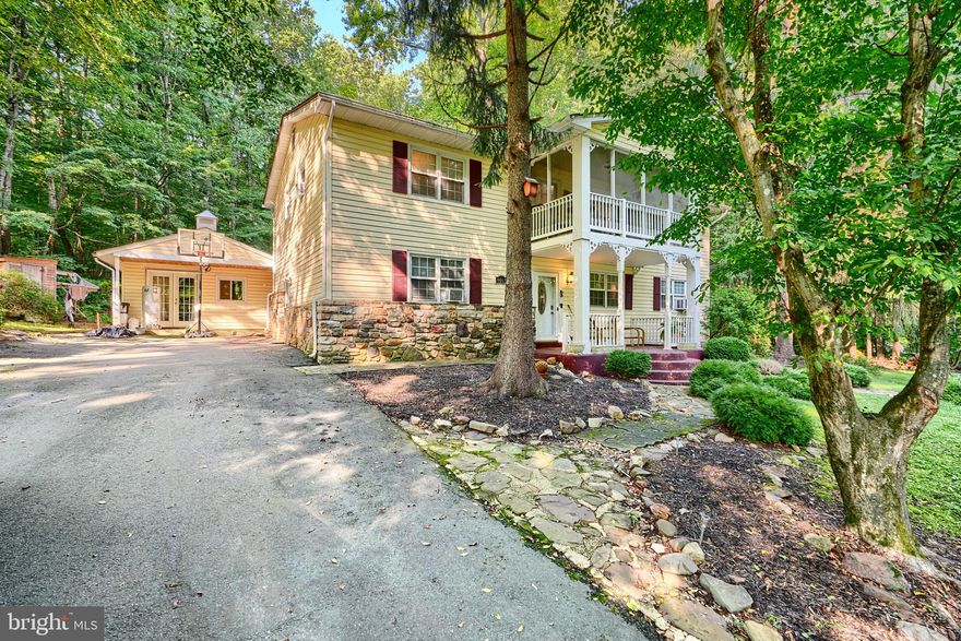 Escape to a life where the water is just steps away and nature frames your backyard. This 3-bedroom, 2-bath Long Beach retreat offers over 2,400 square feet of timeless charm and thoughtful comfort. From the storybook cottage exterior to the stone-clad, wood-burning fireplace, every detail invites you to slow down and savor the moment.

Mornings begin with coffee on the breezy screened porch, evenings unwind with cocktails on the expansive multi-level deck—both perfect for entertaining or simply enjoying the peaceful surroundings. Inside, the sunlit upper level boasts fresh paint, new flooring, and a warm, open flow from the kitchen’s cozy breakfast nook into the living and dining areas. The spacious primary suite and an additional bedroom share this level with a beautifully updated full bath.

The lower level is equally inviting, offering a generous family room with built-ins, a third bedroom, and a second full bath—ideal for guests or private living space. Outside, a detached garage and storage shed provide functionality, while the open backyard seamlessly blends into Flag Ponds Nature Park, creating a rare sense of privacy and connection to the outdoors.

Here, every day feels like a getaway—yet you’re still close to the conveniences of town.