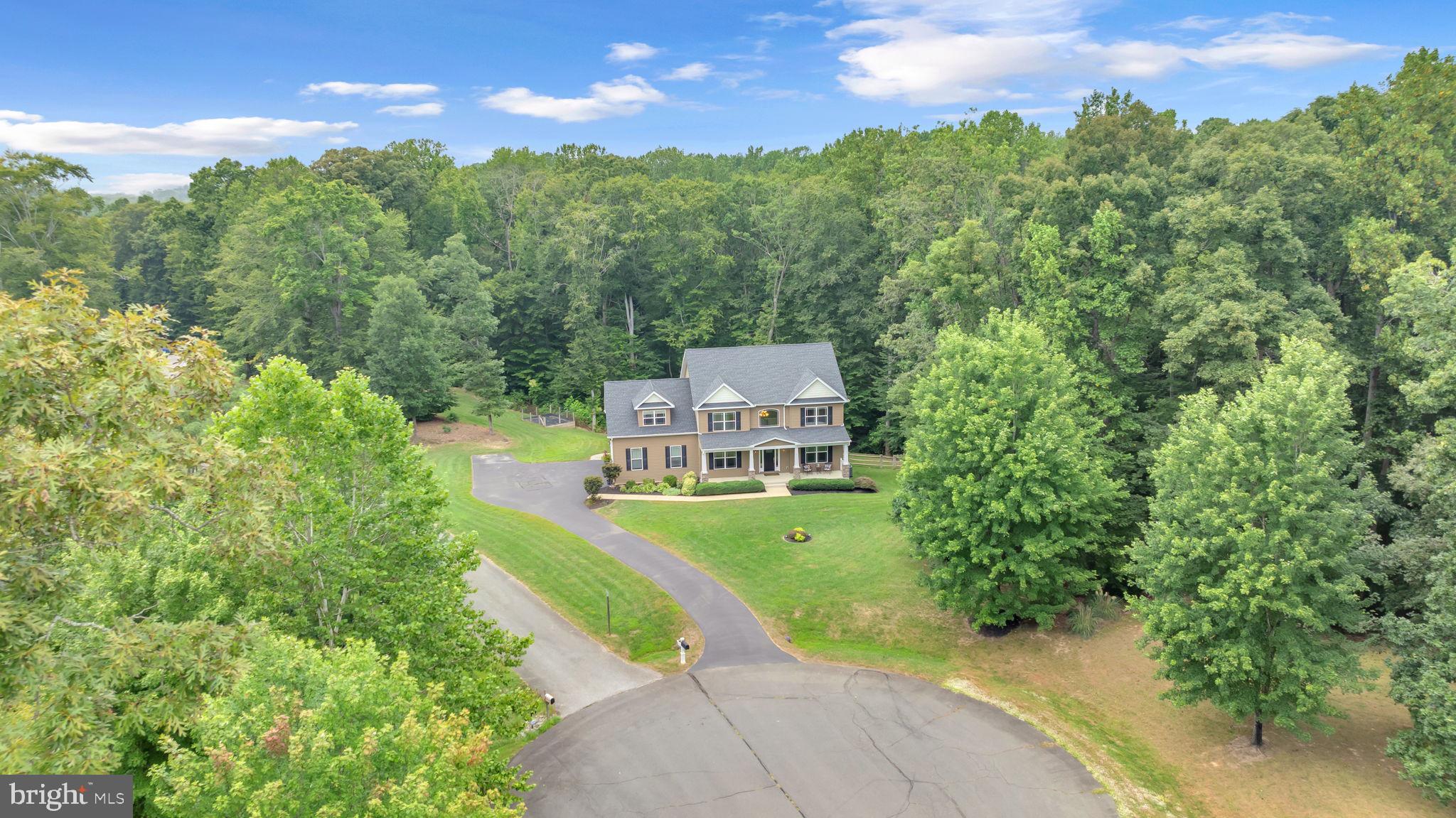 A pristine colonial tucked away on 3 acres at the end of a tranquil cul-de-sac in the sought-after Hollybrook Farm neighborhood. You’ll fall in love the moment you pull up to the relaxing front porch and enjoy nature from the moment you arrive. Inside, a two-story foyer with gleaming hardwood floors opens to formal living and dining rooms with 9-foot ceilings, creating a perfect backdrop for entertaining and everyday living.
The chef’s kitchen shines with upgraded countertops, stainless steel appliances, abundant cabinetry, and a sunny breakfast area. The adjacent family room features surround-sound and a gas fireplace, with natural light pouring in through windows throughout the home. In 2021, the owners added a composite deck and a stunning 14×14 sunroom—ideal for morning coffee or evening gatherings and seamlessly blending indoor and outdoor living.
Upstairs, four spacious bedrooms include an owner’s suite with a tray ceiling and rope lighting, plus a deluxe bathroom with a large walk-in shower, soaking tub and dual sinks. On the opposite side of the upstairs the bonus room over the garage could possibly be another owner's suite with entry to the hall bathroom. The finished basement offers flexible space or an additional bedroom, a full bath, huge recreational area and a dedicated dog grooming wash station—perfect for pet lovers and entertainers alike.
Additional highlights include gas on-demand hot water, an irrigation system around the property, and a 16×24 two-level shed with electricity, 200-amp service and a lean-to for tractor coverage. There is abundant storage throughout this property and numerous special touches that you’ll appreciate on your tour. This residence is close to modern conveniences, schools, and commuting routes, making Hollybrook Farm a true standout—don’t miss the opportunity to make it yours.