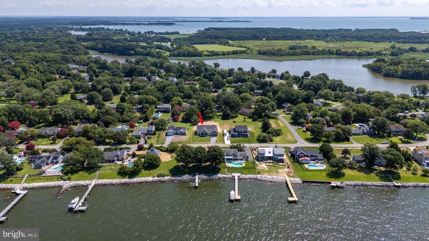 Welcome to this brand new home in the sought after waterfront community of Queen Anne Colony. This 4 bedroom, 3 1/2 bath home is awaiting for you! Queen Anne Colony is nestled between the Chesapeake Bay and Price Creek. Water views of the Chesapeake Bay, spacious, open concept, coastal elegance, one story living and location are just a few of the favorite things about this home! Upgrades galore both inside and out. Starting from the outside with the pillars, siding, stone, garage door, exterior double front door, landscaping (backyard privacy trees already planted for you), cedar ceiling on front porch and a conditioned crawlspace with drain tile and sump pump are just a few. Just enough land for you to stretch out, have your own privacy and own backyard to make it the way you want. No cookie cutter homes in this neighborhood, with super low HOA fees ($10/month). Venturing inside, the dreamy family room, kitchen and eating area are all completely open. Tons of natural light in every room with strategically placed transoms. Custom gas fireplace upgraded with a custom mantle/trim, tile, flanked by cabinets, topped with quartz, that seamlessly match the kitchen. More upgrades with this beautiful home are a step tray ceiling, all other ceilings are 9', all upgraded closets, only wire shelving you will find is in the 2 coat closets, custom built-ins in mudroom, pantry and 1 of the primary closets. Even more upgrades, LVP flooring throughout, the trim, windows and a Rinnai for instant hot water. The kitchen is a showstopper with a 12 ft island, Energy Star appliances, all SS, including 3 "smart" ones and a backsplash. A double wall oven and a 5 burner recessed gas cooktop will make the chef in the home very happy. A butler's pantry, has your microwave and wine/beverage refrigerator included.  The primary bedroom and bathroom are located in the rear of the home, which provides privacy from the other 3. The primary bedroom includes 2 separate walk-in closets. One of the closets has custom built-ins for all your needs. The en suite bathroom includes 2 separate vanities, a tiled shower and free standing soaking tub. It is spacious with a little bit of glam. The laundry/mudroom includes cabinets, a sink, quartz countertops and a custom built-in. The pantry/storage area is a complete room in itself. All closets in the bedrooms are walk-ins (except 1). The outside porches together measure around 450 sqft for extra outdoor living area. Your back porch is ready for peaceful evenings or lively crab feasts. The attached finished garage is around 535 sqft with extra room for storage (bikes, etc.) This  community has a park which consists of a pavilion, playground, picnic tables, basketball court and an open field for homeowners. It also has access to the Chesapeake Bay Overlook with a nice paved entrance and benches for seating. There is a kayak launch for kayaks and canoes with easy access to Price Creek. There is something so special and peaceful in an established community that you can't just "create" in a new development.  Queen Anne Colony is adjacent to several businesses.  A few are the Queen Anne Marina which is a full service marina with boat slips, fuel, utilities, storage, etc. and The Silver Swan Bayside (located inside the neighborhood).  Also, the Blue Heron Golf Course and the South Island Trail (a 7-mile paved trail that ends at the Romancoke Fishing Pier), beaches, another marina and  a restaurant are all within 5 minutes of this new home. This home has the KI vibe you are looking for! Schedule your private showing today, so you won't miss it! MHBR:7172