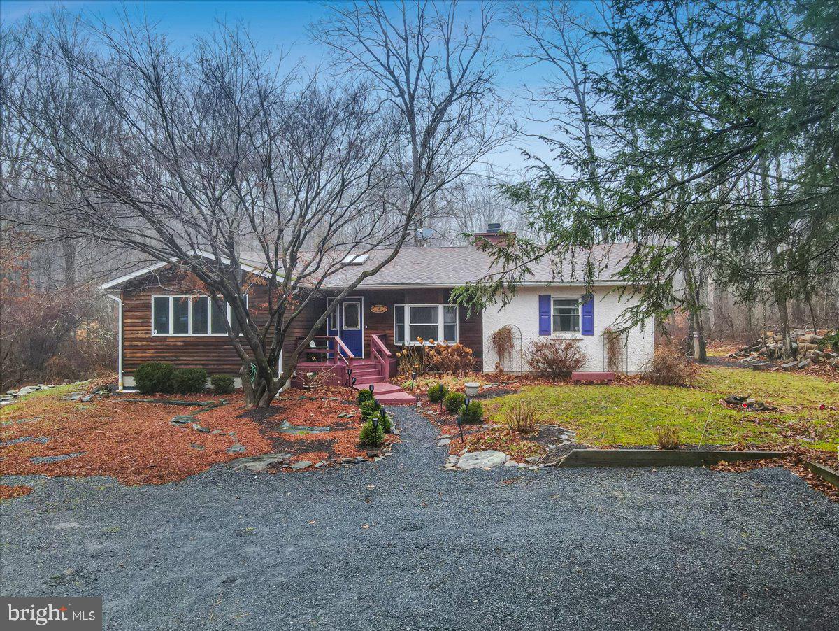 If you are looking for a SERENE ZEN-LIKE COTTAGE setting, NESTLED STREAM SIDE on a 1.70 ACRE LOT for your primary or vacation home with lots of UNIQUE CUSTOM and whimsey features then this charmer is for you! Enjoy 2000 sqft of ONE LEVEL LIVING with 3 BEDROOMS and 2 Full BATHS and CENTRAL A/C! With Beautiful HARDWOOD FLOORS and NATURAL LIGHT flowing throughout, you will instantly feel warmth and inner peace at first sight! A nicely appointed kitchen offering a stainless steel gas stove, built-in BREAKFAST NOOK, GRANITE counters & WINE/COFFEE BAR serves as an aperitif before stepping onto the custom stream side deck ready for your dining pleasure or just your morning coffee chat with an abundance of nature friends, that visit! Inside, cozy up to the CUSTOM TILE FACED WOOD BURNING FIREPLACE
where your next good read awaits you on the CUSTOM BUILT-IN SHELVES in the SUNKEN living room. Three nice size bedrooms artfully furnished and decorated, offer custom tongue and groove accents, whimsey color to fill the senses and lots of glass to allow nature in and both bathrooms are adorned with luxurious tile and custom sink vanities! Still looking to connect with nature on a warm rainy day? Enjoy the screened in porch with tongue and groove vaulted ceiling, also stream side! A tiled floor bonus room allows for a game room or office space in between the screened porch and 2nd bedroom. Located in the heart of the Poconos, convenient to highways and shopping, NO HOA, LOW TAXES. Schedule your private showing to experience the serenity of your next home! Pocono Township does not allow STR's for this house. Pocono Mountain School District. Beautiful Landscaped Gardens in the warmer months!