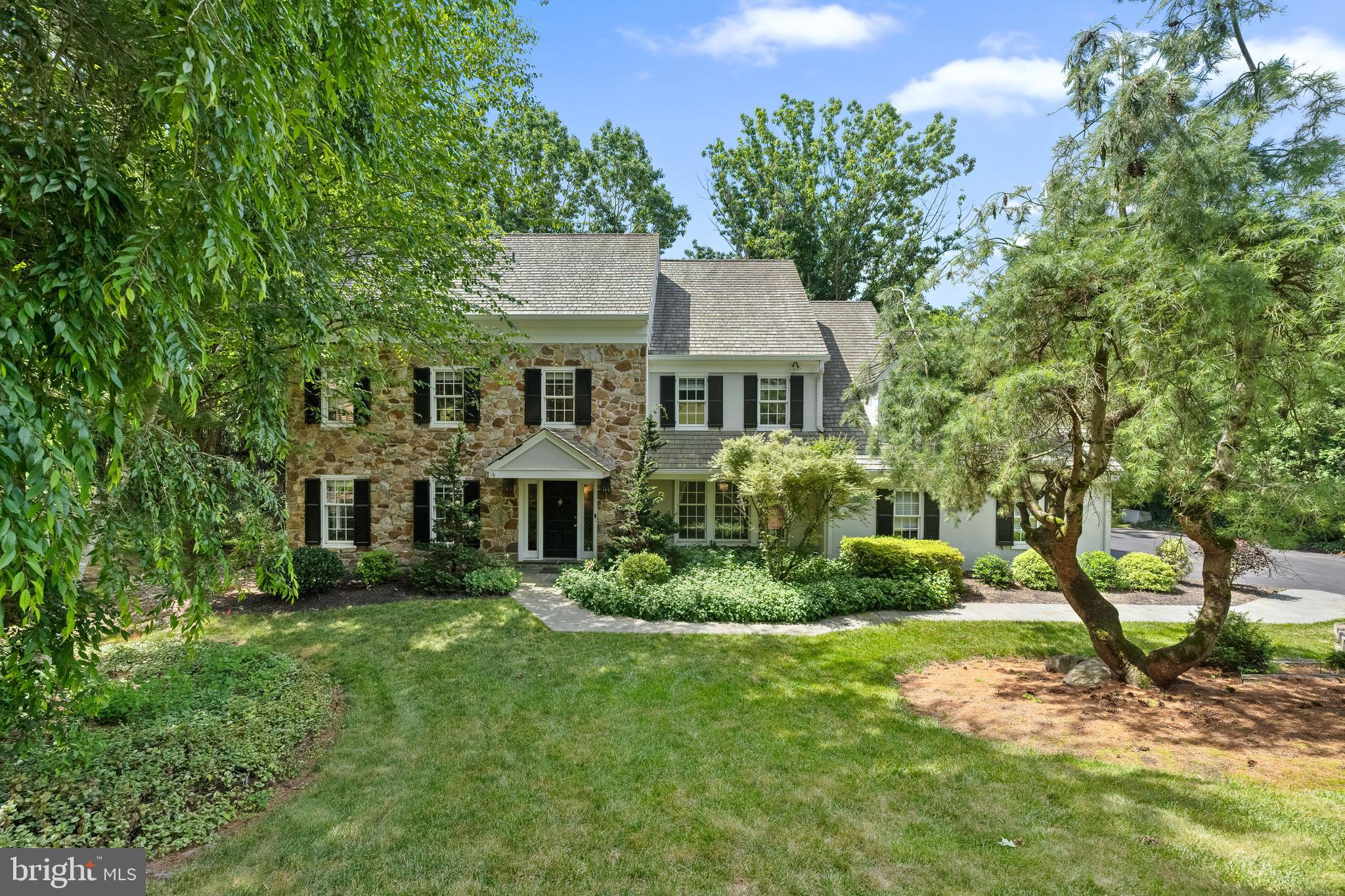 **open house cancelled**Nestled at the end of a quiet cul-de-sac and backing up to open space, in the highly sought-after Ravenscliff neighborhood of Radnor township, this quintessential Main Line 4 bedroom and 3.5 bath colonial home has beautiful outdoor space, an inviting and open floor plan that perfectly complements its park-like setting, and ample room for both relaxation and entertainment.
A flagstone pathway leads you to the front entrance and once inside you are greeted by a bright and airy foyer, with dual coat closets, that seamlessly flows into the dining and living areas, ideal for hosting gatherings with family and friends. There are hardwoods throughout which draw your eye to the oversized living room with cozy fireplace, open to the family room. The two story family room’s focal point is the floor to ceiling stone wood-burning fireplace with built-in shelving, a wet bar and sliding glass doors open to the deck outside, it is an amazing space for entertaining and everyday living. The family room is open to the sunlit breakfast room and kitchen. The light and bright updated kitchen features stainless steel appliances, Thermador double oven, Wolf gas 5 burner cooktop, LG refrigerator, granite countertops, a ceramic tile backsplash. ample counter space, a bar with glass storage and a bar sink perfect for keeping bottles cold during parties, in cabinet lighting, wine and beverage refrigerators and a breakfast room with skylights overlooking the beautifully landscaped backyard. The dining room with chair and crown moldings is spacious and perfect for entertaining. A large mudroom with built in bench & cubbies and laundry room combo offers ample storage space and convenient access from the 2 car garage. A remodeled powder room completes this level.
The large primary suite is a true retreat, complete with a luxurious en-suite bathroom and an expansive custom out fitted walk-in closet. The bathroom features a freestanding soaking tub, double vanity, private W/C, plenty of storage, limestone tile floors and a frameless glass shower with bench seat, waterfall shower head and limestone surround. A second floor landing area just outside the primary bedroom would make the perfect reading nook or office area and overlooks the great room below. The spacious en-suite bedroom has a newly updated bathroom with a beautiful frameless glass shower with waterfall shower head, marble tile, new vanity and lighting, a wifi enabled sound system and a linen closet. The remaining two bedrooms each with double closets are generously sized and share the neutral hall bath with new marble topped vanity, linen closet and tub/shower combination.
The lower level is partially finished and features a temperature controlled wine room and an additional family room with tile floor, which is perfect as a game or tv room. The unfinished space offers ample storage, a walk in cedar closet and a workshop.
Step outside to enjoy the tranquil surroundings and beautifully maintained grounds, offering a perfect backdrop for outdoor activities and peaceful relaxation. The quiet cul-de-sac location enhances the sense of privacy and community, making it an ideal spot for those seeking both convenience and serenity.
All of this is located in the award-winning Radnor School District, around the corner from the Willows park and minutes from downtown Wayne with its shops, restaurants, and train station, in addition to offering ease of access to major highways, Center City, Newtown Square and the airport.