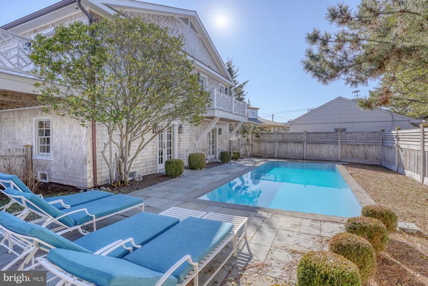 Charming Coastal Cottage with Inground Pool, Just Steps from Lewes Beach and Delaware Bay!
This exquisite Lewes Beach cottage underwent a full renovation in 2014, blending modern upgrades and exceptional craftsmanship while preserving its timeless cottage appeal. Featuring new cedar shake siding, a cedar shake roof, and copper gutters, the home maintains its coastal charm and character.
The second-floor entry foyer greets you with tongue-and-groove wood walls and hardwood floors. To the right, you'll find the kitchen, while a wine bar area with a refrigerator leads into the spacious great room ahead. The tongue and grove wood wall detailing continues throughout the entire second level. The great room boasts a white-painted brick fireplace with a custom wood mantle and coffered ceilings. Three sets of French doors open to a wraparound Ipe deck with a retractable awning, perfect for enjoying the refreshing bay breezes.  The chef's kitchen is a true highlight, featuring crisp white cabinetry, quartz countertops, a stylish tile backsplash, and top-of-the-line stainless steel appliances. The kitchen flows into the dining room, which includes a built-in china cabinet. Adjacent to the dining room is a sun-filled sunroom offering beautiful views of the beach and bay. The open floor plan is ideal for entertaining guests.
This level also offers three bedrooms, each with access to the Ipe decks. The hallway bathroom features a tub and shower with white subway tile and marble floors. There’s also a convenient laundry room on this floor. The Owner’s Suite is a retreat with a walk-in closet and custom closet system, a luxurious bathroom with a Carrera marble shower, and access to a private deck overlooking the pool.  The first floor is a spacious entertaining area, complete with a large game and family room. Two sets of doors lead directly to the heated pool. Also on this floor is a full bathroom, a fitness room, and a garage. After a day at the beach, rinse off in the outdoor shower.   Outside, the backyard is an oasis, with a large heated pool surrounded by a bluestone paver patio and a high privacy fence made of western red cedar. New landscaping, flagstone walkways, and a honeywheat aggregate stone driveway add to the property’s coastal charm.
Located just steps from the beach, boating, restaurants, and Lewes attractions, this cottage offers the ideal coastal lifestyle. Whether you're seeking a beach retreat, a year-round home, or a property with rental potential, this is your perfect escape. Don’t miss out—take the video tour today!
