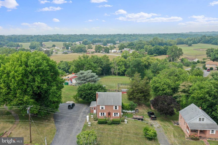 Well maintained all brick 4 bedroom home on 0.89 unrestricted acres. Over 2300 sf of finished living space!  The home is bright and airy and the lot features mature trees. There is a den/office on the main level, formal living and dining rooms, lovely country kitchen with center island and a full bath plus laundry room.  Back door exits to a small patio at the gorgeous view of the spacious back yard and fenced area with barn/run-in.  Hardwood floors throughout with stone tile kitchen floor.  Wood buring fireplace, replacement windows, garage door access side of home (would need modified to use for car parking), and large unfinished basement.  The finished walk-up attic has loads of potential and is accessed from the upper bedroom, perfect for owner, in-law, or anyone who would need or want a little extra!  Shed, barn, 3 stall run-in, fenced pasture.  Electric has been upgraded.  Great commuter location to I81 and I70, Maryland.