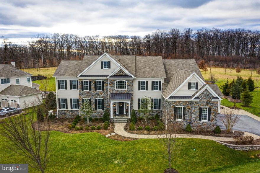 Outstanding stone colonial manor home featuring the desirable Henley Lexington floorplan from  the Villanova Collection of Grand Manor Homes with an  abundance of upgrades! Situated on a one of the best lots in the gated estate section of the sought after Liseter community on almost an acre of land bordering open space and the beautiful preserve area, this impressive home features almost as many upgrades as the Liseter Model home including 10 foot ceilings on the 1st floor, beautiful custom hand scraped hardwood floors, and over 8,000 square feet of exquisite finished space  with 5 bedrooms, 5 full baths and 1 powder room.  The exterior features an expanded driveway outlined with custom pavers, extensive professionally manicured landscaping, exterior lighting, an expansive entertaining deck, and a winding flagstone walkway leading to the impressive front door. A grand entrance with double columns leads to the front portico and oversized solid wood front door flanked by two sidelights.  The interior of the exquisite center hall offers an inviting double butterfly curved staircase with landing accentuated by a 2-story ceiling, custom hand scraped hardwood flooring throughout the 1st floor, exceptional custom millwork throughout including oversized crown moldings, chair rails, and baseboards in the elegant dining room w/ a crystal chandelier, a formal living room that leads to the executive office/study w/ French doors, designer pendant lighting, custom wood blinds and triple window overlooking rear grounds.  A private hall leads to the impressive conservatory that boasts a picturesque triple window adjoined with four additional windows. The large chef’s kitchen offers an oversized island and beautiful custom cabinetry including glass displays, granite counters, upgraded appliances including a 6-burner Wolf range, cabinet faced Jenn Air refrigerator and Kitchen Aid dishwasher, built-in Wolf microwave and oven, large corner walk-in pantry, custom herringbone stone backsplash w/ glass tile inlay.  Kitchen opens to a large sunny breakfast room with built-in desk and also opens to a bonus sun room w/ walls-of-windows offering magnificent views of the rear grounds.  There is a central 2-story great room w/ floor-to-ceiling windows and gas fireplace w/extensive custom millwork and impressive dental molding mantel.  Interior features also include a luxurious Master Suite with a large bedroom and private sitting room, sumptuous master bathroom with his and hers vanities, oversized double glass door shower and oval whirlpool soaking tub, two commode rooms, and his and hers custom outfitted closets.  The 2nd floor hallway leads to two additional ensuite bedrooms w/ double sliding door closets and full bathrooms.  Two additional bedrooms adjoin with a Jack andJill bath w/single vanity and tub/shower combo. The daylight walk-out lower level was recently finished and features state-of-the-art fitness center w/professional grade rubber flooring, expansive wet bar entertaining area w/ granite countertops, custom cabinetry, beverage fridge and dishwasher, elegant 5th full bath w/ marble and  frameless glass shower, and large media area w/ waterproof wood flooring w/ cork underlay.  The oversized deck off the back of the house features stairs to the the rear yard and offers breathtaking views of the bucolic setting.  The Liseter community offers upscale amenities including a 9,000 square foot restored barn serving as a Clubhouse, a 2nd clubhouse, fitness center w/ classes, sports courts, and an infinity pool, tennis courts and walking trails.  This spectacular home is convenient to the airport, corporate centers, Episcopal Academy, towns of Newtown Square, Wayne, Paoli and Devon and many area golf courses.  Don't miss this opportunity!
