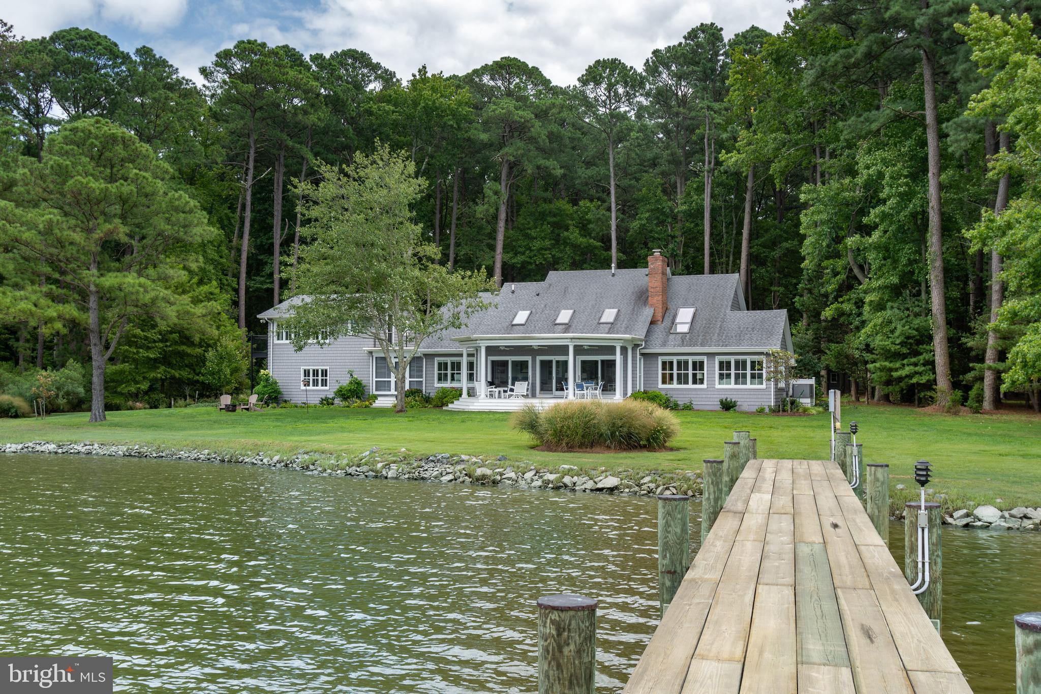 This exceptional waterfront estate, nestled on approximately 4.25 private acres with sunset views of Plaindealing Creek, features a custom pier equipped with electric, water, along with a rip-rapped shoreline. Positioned just off the Tred Avon River, the property includes a fully irrigated lawn, a year round porch with brick flooring and separate HVAC. There is also a waterside composite deck. The meticulously maintained four-bedroom residence boasts antique wood flooring throughout, a stunning gourmet kitchen, waterside great room with fireplace and custom built-ins, and separate den/family room with beautiful built-ins. The main-level owner's suite offers custom closets and a luxurious bathroom with a freestanding soaking tub and a separate tiled shower. Upstairs, you'll find a cozy loft ideal for a library or sitting area, custom skylights with power shades, and a rooftop balcony that connects to a finished bedroom/craft room over the attached two car garage. Additional amenities include a detached two-car garage with a bonus area above, a detached RV garage, and a boat shed. Conveniently located just minutes from Historic Easton and St. Michaels.