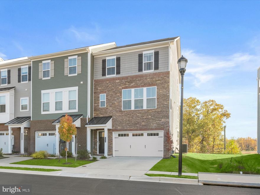 Built in 2022 and maintained by its original owners, this beautiful end-unit garage townhome showcases the sought-after St. Michael model by Beazer Homes, the largest floor plan offered. With upgraded stone accents enhancing the exterior and thoughtful upgrades throughout, this home blends style, comfort, and convenience in a desirable Hanover location.
Step inside to an inviting open-concept main level designed for modern living. The kitchen sits perfectly between the living and dining rooms, creating an effortless flow for daily life and entertaining. Luxury vinyl plank flooring extends throughout this level, complementing the home’s natural light and high ceilings. The kitchen is a standout feature with 42-inch cabinetry including display cabinets, an expansive island with a breakfast bar, granite countertops, stainless steel appliances, and an apron sink. The adjoining living room opens through a sliding glass door to a deck overlooking peaceful trees, providing the ideal spot to relax outdoors.
Upstairs, the generously sized primary bedroom offers a walk-in closet and a private en suite bath featuring a double sink vanity and a tiled shower with a frameless glass door. Two additional bedrooms share a stylish full bath, while the convenient upper-level laundry adds ease to everyday routines. Both full bathrooms are finished with sleek quartz countertops.
The lower level provides a comfortable family room with a sliding glass door to the backyard, a convenient half bath, and interior access to the oversized 1.5-car garage with extra storage space. Additional highlights include recessed lighting throughout and visitor parking nearby.
Set in a prime location, Fox Glove Lane offers access to countless amenities. Residents enjoy proximity to Arundel Mills for shopping and entertainment, along with nearby grocery stores and retail centers. Outdoor recreation is easy to enjoy with community playgrounds, and access to the scenic BWI Trail. This modern, light-filled home combines suburban tranquility with exceptional convenience.