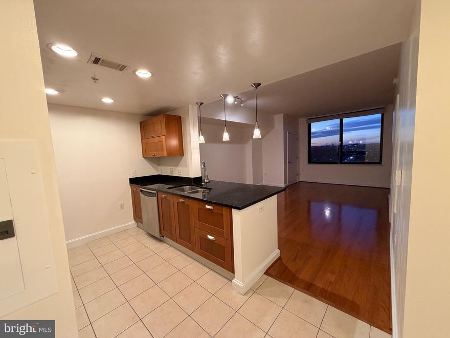 Elevated 16th-floor penthouse with expansive views and private key-fob elevator access. The residence features hardwood floors in the living and dining areas, ceramic tile in the kitchen and bath, and a spacious bedroom with plush carpeting, all in excellent condition with fresh paint throughout.
The kitchen is both functional and refined, offering granite countertops, stainless steel appliances, a built-in microwave, and pendant lighting over the breakfast bar. In-unit washer and dryer included for everyday convenience.
One assigned, covered parking space is located on the second floor. The building offers secure, controlled entry and access to well-maintained 7th-floor amenities, including a billiards lounge.
Located at Midtown Alexandria Station, with easy access to I-495, Fort Belvoir, Reagan National Airport, and Old Town Alexandria.