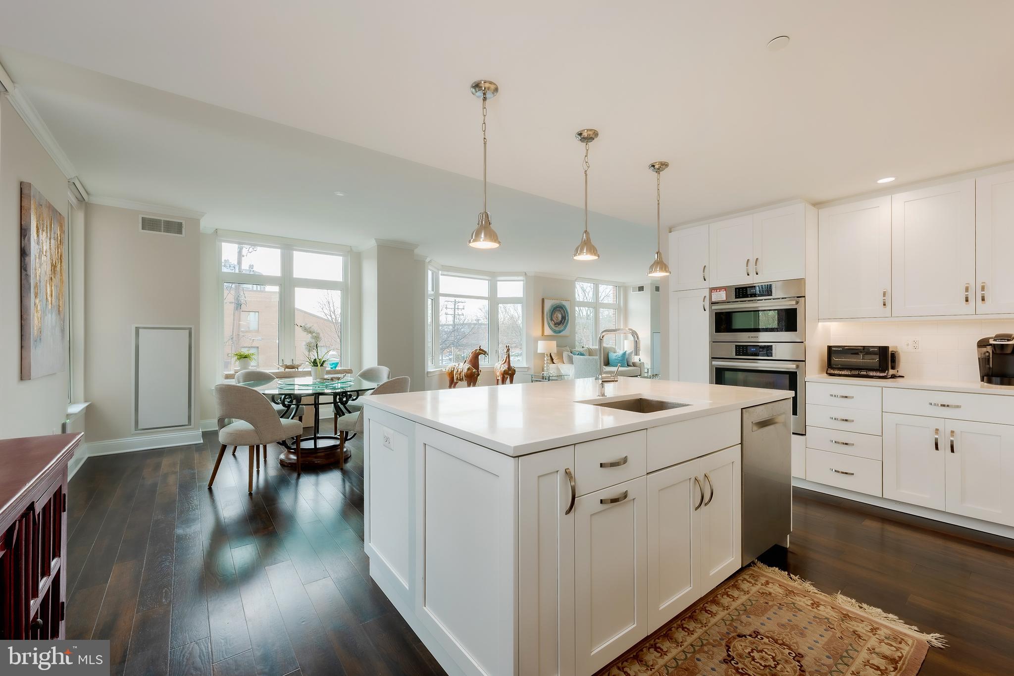 Experience unparalleled elegance and sophistication with this exceptional residence: a seamlessly combined unit at Hampden Row, located at 4915 Hampden Lane. Recognized as the #1 Best New Luxury Condominium in 2017 by Bethesda Magazine, this Toll Brothers development epitomizes timeless design and modern living in the vibrant heart of Bethesda.
Upon arrival, step into a 2,700+ square-foot haven, where thoughtful design and premium craftsmanship merge to create a truly inviting and luxurious home. Oversized windows, soaring 9-foot ceilings, and 5-inch-wide plank hardwood floors frame a light-filled interior adorned with custom white cabinetry and exquisite finishes throughout. The meticulously designed kitchen showcases: Quartz countertops with clean, modern lines. A suite of high-performance appliances by Gaggenau®, Thermador®, and Bosch®. Sleek Grohe® fixtures that elevate both style and functionality.
This grand residence boasts an exceptional layout designed for privacy, versatility, and ultimate comfort:
Three spacious bedrooms, including two primary suites.
A flexible den/office perfect for work or quiet reflection.
Three full bathrooms and an elegantly designed powder room.
Two private balconies, perfect for relaxing or entertaining.
Two laundry closets for added convenience.
Abundant closet space to meet every storage need.
A Perfect Layout for Modern Living
Off the foyer, a private primary suite with an ensuite bath and walk-in closet creates an ideal in-law suite or guest retreat. From there, the home opens into the light-filled dining, kitchen, and living areas, where contemporary elegance meets warmth and functionality.
Adjacent to the living area, a den/office provides a dedicated space for work or study. Another bright bedroom, paired with a nearby full bath featuring a soaking tub, offers versatility and convenience.
A private corridor leads to a second living area that mirrors the exquisite design of the main space, culminating in another primary suite with a luxurious ensuite bath, walk-in closet, and its own laundry area.
Two dedicated parking spaces equipped with electric vehicle (EV) readiness, ensuring convenience for sustainable living.
Unrivaled Community Amenities
As a resident of Hampden Row, you’ll enjoy exclusive access to an array of luxurious amenities, including:
24/7 concierge service, providing personalized attention.
A fully equipped fitness center for your wellness needs.
A refined club room for private events and gatherings.
Two stunning rooftop decks with grills, a cozy fireplace, and sweeping views – the perfect setting for al fresco dining or relaxing under the stars.
Prime Bethesda Location
Set on the serene Hampden Lane, this luxurious residence offers a peaceful retreat just steps from the metro and the bustling Bethesda Row. Enjoy immediate access to Bethesda’s finest shopping, dining, and entertainment, blending convenience with tranquility.