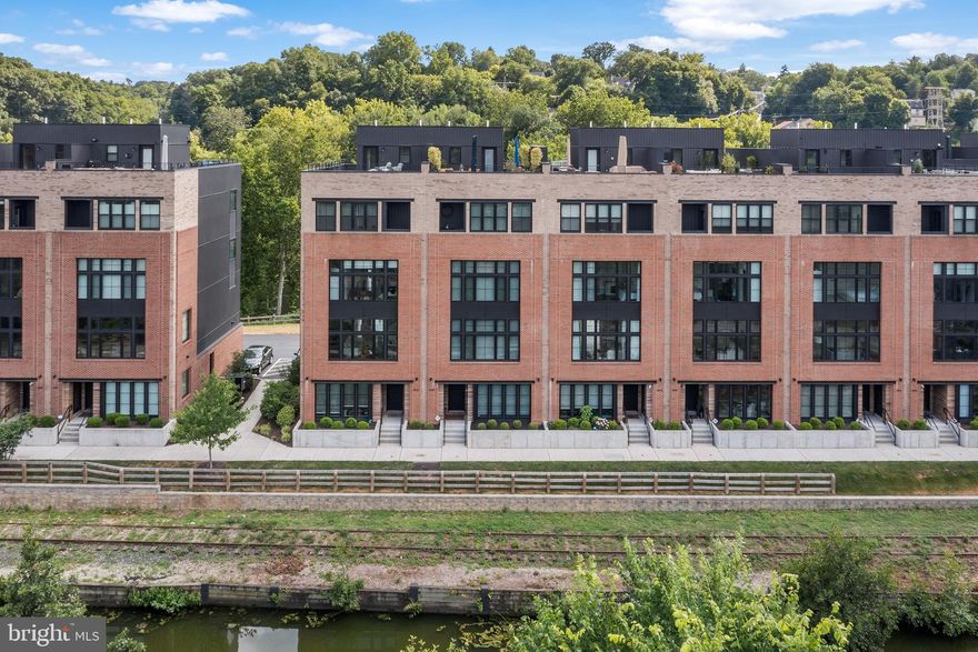 Water views from every window! Welcome to 4535 Riverside, where you can experience modern luxury waterfront living on Venice Island in Manayunk, just a stones throw from center city! This is one of only 11 homes within The Locks community that has unobstructed views of both the Schuylkill River and the Manayunk Canal and is extra wide (23 ft!). The Loire Model is an expansive 3,680 square feet, has an OVERSIZED 2 CAR GARAGE, four bedrooms, three full bathrooms and a powder room, a den on first floor, a den off of the primary suite, an amazing full length roof deck with breathtaking views, a five stop elevator, and 7+ years left on the TAX ABATEMENT. Oversized windows throughout maximize the natural light and viewpoints, making you feel like you are living nowhere near a major city. Notice tons of upgrades in the home including wide plank natural wood hardwood flooring, a high end Thermador and Bosch appliance package, a wet bar with beverage center outside of the primary suite, and automated blinds throughout including blackout blinds on the primary suite floor. The sun-soaked, wide open living space is truly an entertainer's dream with views everywhere you turn, an enormous living area, full dining room, and sitting room off of the kitchen. Kitchen is complete with a large island, modern shaker style cabinetry, quartzite countertops and a pantry closet. Three generously sized guest rooms (one with an en-suite bathroom), a hall bathroom and laundry room on the third floor. The  primary suite boasts three large closets, a separate den/office space, a five piece bathroom with soaking tub, and a covered terrace facing the canal. Head up to the roof deck to enjoy the unparalleled 360 degree views! Enjoy walking to Main Street for lots of dining and shopping options, or get to center city within minutes via train or car! Easy access to all major highways. Live in luxury and convenience at The Locks!