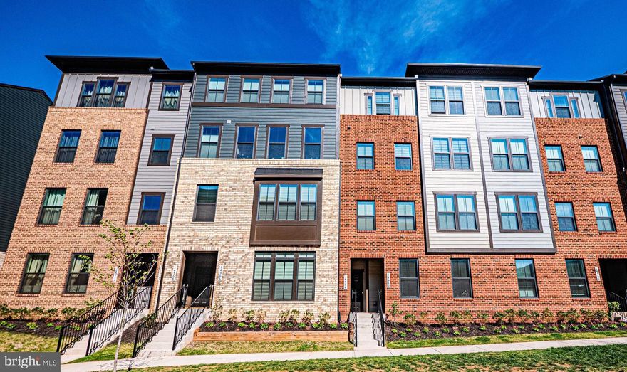 Gorgeous 2025-built townhome located in Ellipse at Westfields, one of Chantilly’s premier subdivisions. Luxury LVP flooring spans the entire main level, complemented by thick, plush designer carpet throughout the upper level. This stunning home showcases thoughtful design and high-end finishes at every turn.
The open-concept kitchen and dining area features stainless steel appliances, quartz countertops, a pantry, a blend of pendant and recessed lighting, and a meticulously crafted culinary station perfect as a coffee bar or butler’s pantry offering additional sleek quartz surfaces, and floor-to-ceiling custom cabinetry with designer matte black hardware and glass-front display accents. The kitchen flows seamlessly into the family room, where dual sliding glass doors lead to a private, covered outdoor living space anchored by a striking fireplace. A high-contrast stacked stone surround paired with a sleek stainless steel linear firebox creates the perfect balance of rustic warmth and modern sophistication ideal for year-round entertaining.
Upstairs, the oversized primary suite features tray ceilings and two fully customized walk-in dressing rooms designed for maximum organization and luxury. Each space is outfitted with thoughtfully designed modular shelving systems, double-hang rods, and built-in storage solutions that create a seamless, high-end closet experience rarely found in new construction. The spa-inspired en-suite bath includes tiled floors, dual vanities with stone countertops, and a modern shower enclosure with black metal framing and a swing door.Two additional spacious bedrooms ,one enhanced with a custom closet system, complete the upper level with both sharing a beautifully appointed full hall bath with a full-size vanity with stone countertops, tiled flooring, and a tiled tub/shower combination. A convenient upper-level hallway laundry includes a stacked GE Profile Smart washer and dryer in a stunning Sapphire Blue finish, featuring UltraFresh Vent System+ and Wi-Fi connectivity—an elevated upgrade not typically included in new construction. Custom zebra-style dual shades throughout provide the perfect balance of privacy and natural light while enhancing the home’s modern aesthetic.The lower level includes a one-car garage, completing this exceptionally upgraded and truly move-in ready home. WHY WAIT FOR NEW CONSTRUCTION WHEN ALL THE HIGH-END UPGRADES HAVE ALREADY BEEN DONE FOR YOU?