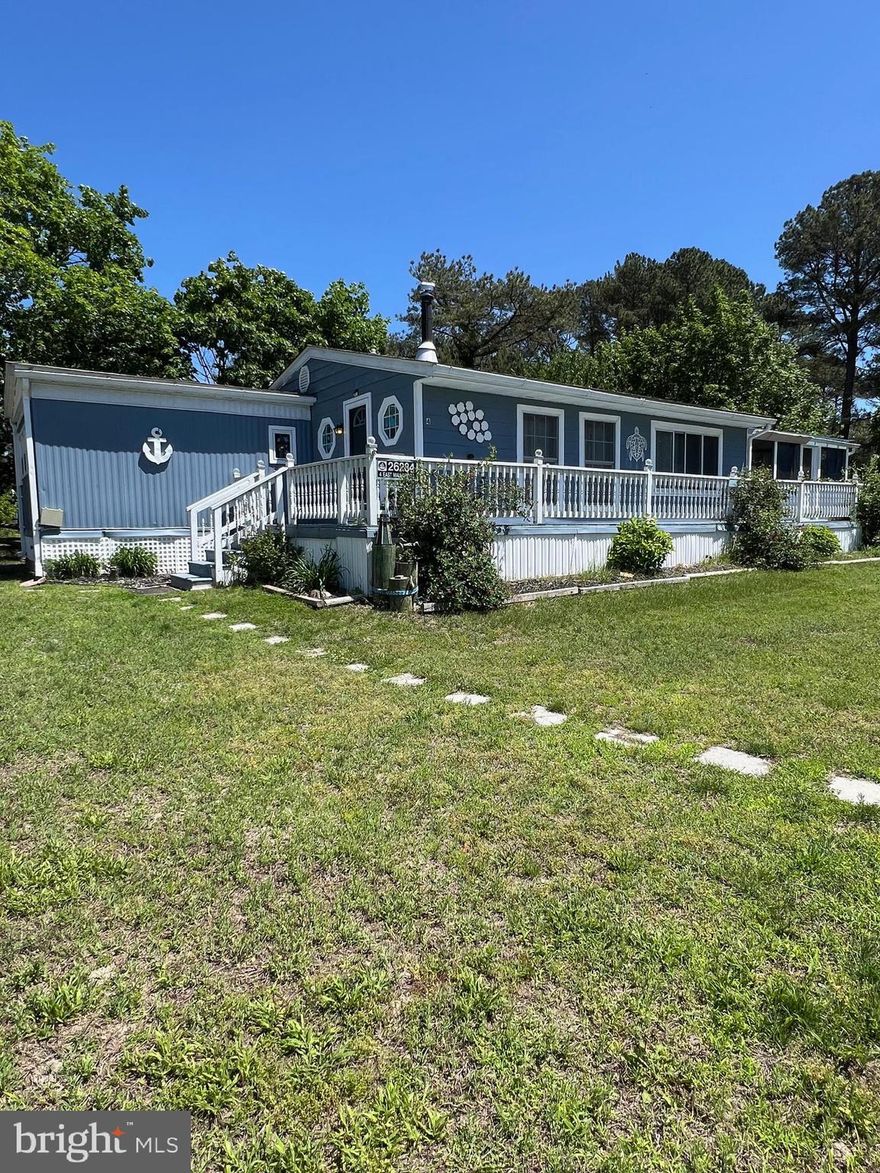 Enjoy water access to both Rehoboth Bay and Indian River Bay in the desirable Dockside community, located near the end of the peninsula with a public boat ramp, community docking, and a boat ramp just steps away. This private setting offers a spacious, tree-surrounded lot that provides exceptional seclusion.

This three-bedroom, two-full-bath home has seen numerous improvements. Updates include a new roof, five mini-split systems installed in 2023, upgraded electrical, and a larger-capacity water heater. Following minor water incidents, sections of subflooring were replaced and vinyl plank flooring installed throughout.

Enter the home through a bright sunroom featuring a wood-burning potbelly stove and French doors leading into the kitchen. The kitchen is well-appointed with stainless steel appliances and a large island with Corian countertops that comfortably seats three. The open-concept layout flows into the living area, offering ample space for entertaining. A gas fireplace is present in the living room (not currently connected). From here, step out to the front screened porch for additional relaxation space.

The primary bedroom is located at one end of the home and features an en suite bath with a deep soaking tub/shower combination. The second bedroom includes built-in storage cabinetry, while the third bedroom is situated at the opposite end of the home near the guest bathroom, which offers a tiled walk-in shower. The rear yard is partially fenced.

Residents enjoy access to Pot-Nets amenities, including a private beach in the Seaside community on Indian River Bay, a swimming pool, restaurant, and marina located across the street. Trash service is included in the ground lease.