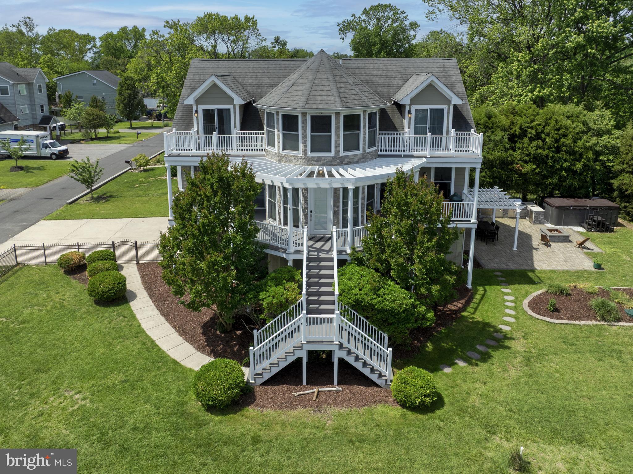Welcome to Bayside Beach, and one of its most stunning homes. Enjoy expansive views of the Bay on each level, from the inside and out. The home was designed to entertain, from the wrap around deck on the main level, fully fenced yard, to the palatial outdoor entertainment space complete with outdoor kitchen, wet bar, and swim spa. Relax by the koi pond under the shaded pergola, cool off in the swim spa, unwind on the deck and watch the local scenery pass by, or sit by the fire on the late summer nights with friends.
Inside continues to impress with its elegant open design and custom touches. The main level welcomes you with warm hardwood floors and floor to ceiling windows throughout. The kitchen is well appointed with granite counters, custom cabinets, stainless steel appliances, and a customizable display wall. The owner's suite will spoil you with the beautiful views of the Bay, dual walk-in closets, and a large en-suite bathroom with large soaking tub. The back of the main level offers a separate dining area, large walk-in pantry, and laundry room.
The upper level and it's 3 large bedrooms boast two separate balconies off the right and left bedroom, while the center bedroom offers 5 windows showcasing incredible views of the Bay, a perfect place to watch ships passing by. The back half of the upper level provides ample attic space/storage through the length of the home.
On the ground level you will find two oversized garage spaces and a workshop offering a whole level of space. Stay warm in the winter while doing your projects with the pellet stove and insulated garage doors. The charming Bayside Beach Community offers a beautiful sandy beach, two boat ramps, a playground, and covered pavilion. All within a quick walk. Conveniently located near two local marinas, several restaurants, Compass Pointe Golf Course, Historic Hancock's Resolution, and Fort Smallwood Park. Come see what the best of the Bay has to offer!