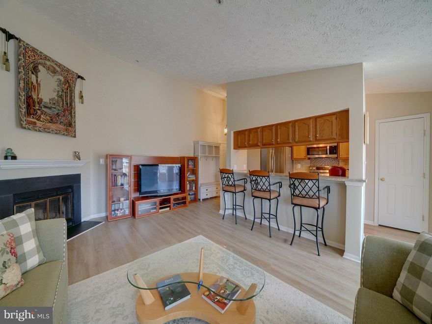 Rare find! This immaculate, top floor condo features  two spacious bedrooms and two full baths. Large room sizes, including a separate dining room with ample light from the windows and skylights and door to deck. 3rd floor location provided upgraded vaulted ceilings for an open and airy setting. Large living room has a cozy wood burning fireplace with mantle. The granite countertop breakfast bar has a pass through to the beautifully upgraded kitchen. The kitchen has SS appliances, tiled backsplash and wood cabinetry. Both bathrooms have been updated, including the primary en suite with tiled showers and upgraded vanities. Convenient laundry room not found in many condos with easy access to HWH.  Throughout the home there are LVP floors and custom window treatments including blinds. Outside the covered deck has  room for outdoor seating to enjoy the wonderful treed community setting. 
Located in Elkridge with easy access to major roadways, MARC train station, BWI airport and plenty of shopping. The Elkridge Library and local recreational parks are very popular. Minutes to NSA/Ft Meade, BWI business district and popular location for commuters to both Baltimore and Washington. This home will not last long. Call your Agent today for a private tour.