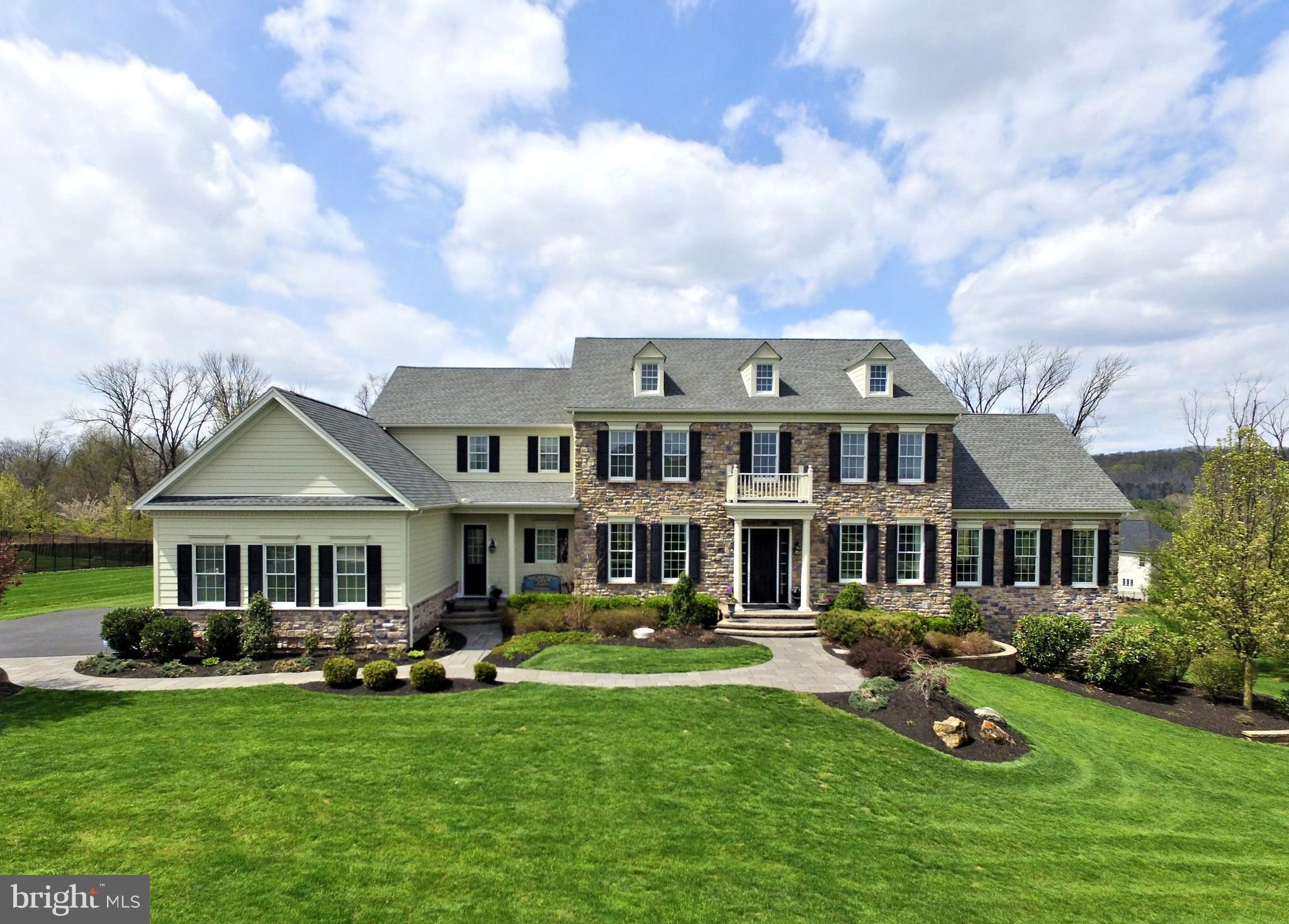 Perched perfectly on over one immaculately maintained acre sits this classic Toll Brothers Stone/Hardie Plank Chamberlain model estate home. Located in one of Upper Makefield's most sought after and prestigious communities, Dutchess Farm Estates, this home offers the discriminating buyer a wide array of luxurious features, and is in mint, turnkey, move-in condition. Enter the soaring two story foyer, featuring an elegant curved staircase with gorgeous oak treads and railing and sparkling white balusters. Spectacular, gleaming Brazilian Cherry hardwood floors are present throughout the entire home. Impressive 10' first floor ceilings, 9' upper level ceilings, ample and detailed crown, trim, and box moldings are featured throughout as well. The elegant formal dining room, along with Butler's Pantry, with tray ceiling and wall sconces is to the left, formal living room is to the right. Double doors will lead from the LR to the giant grand conservatory, which features a cathedral ceiling, floor to ceiling stone fireplace, walls of windows facing Jericho Mountain, and three distinct areas of use- entertainment area, children's play area, and cozy sitting area for curling up with your favorite book. The gourmet kitchen /breakfast room, with Palladium addition is a chef's delight, featuring a large center island with seating for 4, beautiful stainless-steel appliances including Jenn Aire 6 burner stove w/ full oven and stainless range hood, double wall oven and convection / microwave, 48" side by side refrigerator / freezer, granite counters, 42" cabinets, under cabinet lighting, tumbled stone backsplash, walk-in pantry, wine cooler, tons of cabinet space, and oversized double French Doors leading to the deck, patio, covered porch, pool and over sized spa. A convenient rear staircase, with oak treads, leads directly to this phenomenal kitchen. The spacious family room, featuring floor to ceiling stone fireplace is adjacent and open to the kitchen. A large home office / study with Cherry built-ins (and access to the conservatory), laundry/mud room with outside door to vestibule/porch, and powder room complete the first floor.The upper level, with 9' ceilings, features a total of 4 bright and airy bedrooms, including the beautiful Master Suite. Bedrooms 2, 3 and 4 all have private baths with upgraded fixtures, 2 & 4 have walk in closets, and all have ceiling fans. The fabulous Master Suite consists of a large sitting room with fireplace and coffered ceiling, main bedroom with coffered ceiling, luxurious Master Bath with oversized Ultra Shower, jetted tub, his and hers large walk in closets, his and hers granite counter vanities, and upgraded tile flooring. The giant daylight lower level features a walk out, extra ceiling height, rough-in plumbing, walls of windows, all with plantation shutters, and offers the opportunity to add your personal design and finishing touch. Outside, your luxury resort style oasis awaits, with maintenance free deck, large screened in porch, Turkish Travertine patio, free form in-ground salt water pool with waterfall feature, separate hot tub for 12, stone fireplace, and large lawn area for field sports and other activities, all backing to woods and offering the ultimate in privacy and amenities. The grounds, lawn, and plantings are lush and impeccable. A flagstone paver front walkway, 3 car garage with custom carriage style doors, 3 zone Heat/AC with Honeywell premium whole house humidifier, pre plumbed for irrigation , security system, and many more amenities are found in this spectacular home. Conveniently situated just across the street from the community's school bus stop, the home is in the heart of the Council Rock School District, just minutes from Newtown Boro and New Hope Boro, I-95 and New Jersey bridges. The home and property have been lovingly maintained, and are offered for the first time by its original owners.